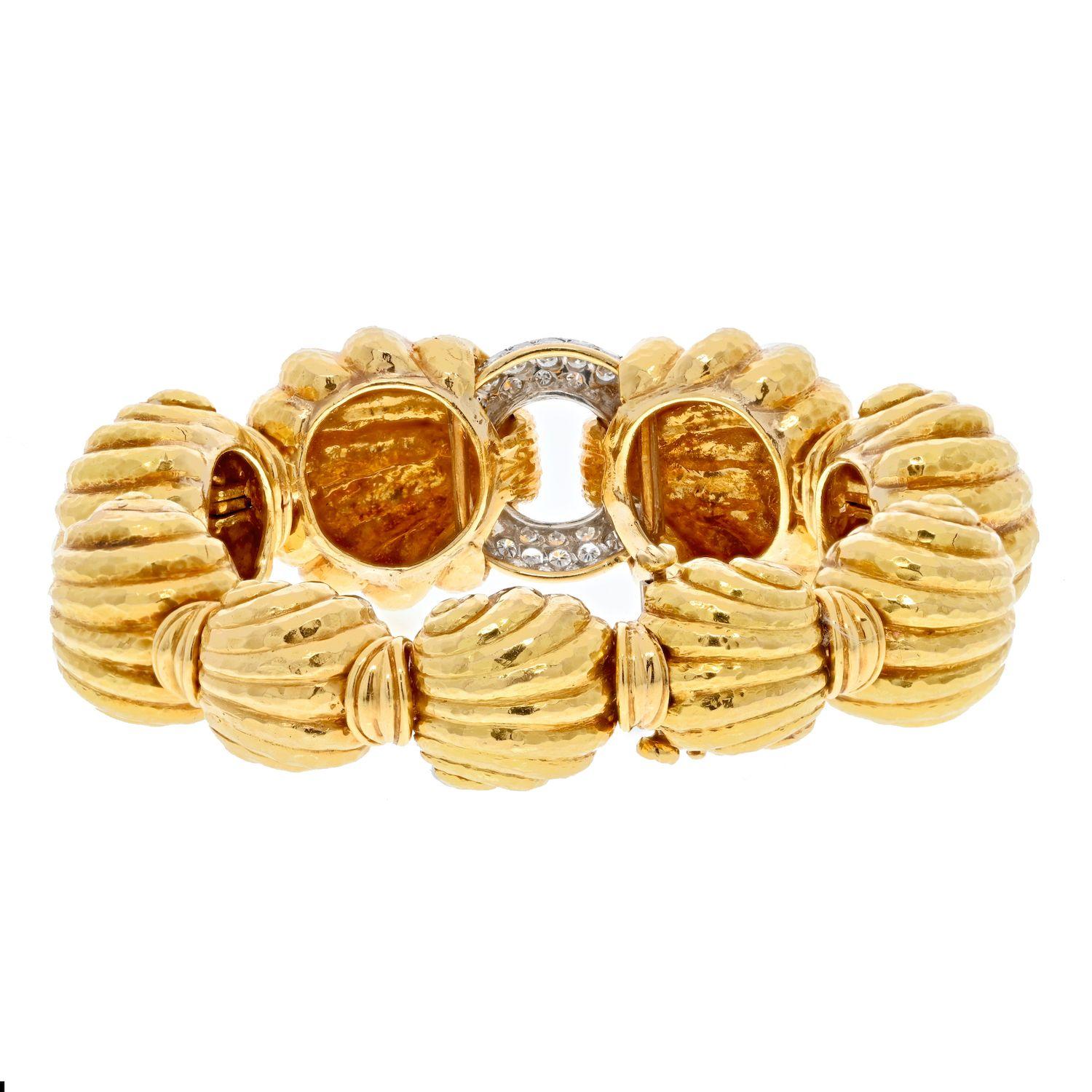 Innovative in everything he does this David Webb yellow gold bracelet is no exception: Escargot fluted bombe link bracleet with a diamond paved center link will certainly end up on the wrist of the creative one. Each bombe link resembles a sea shell