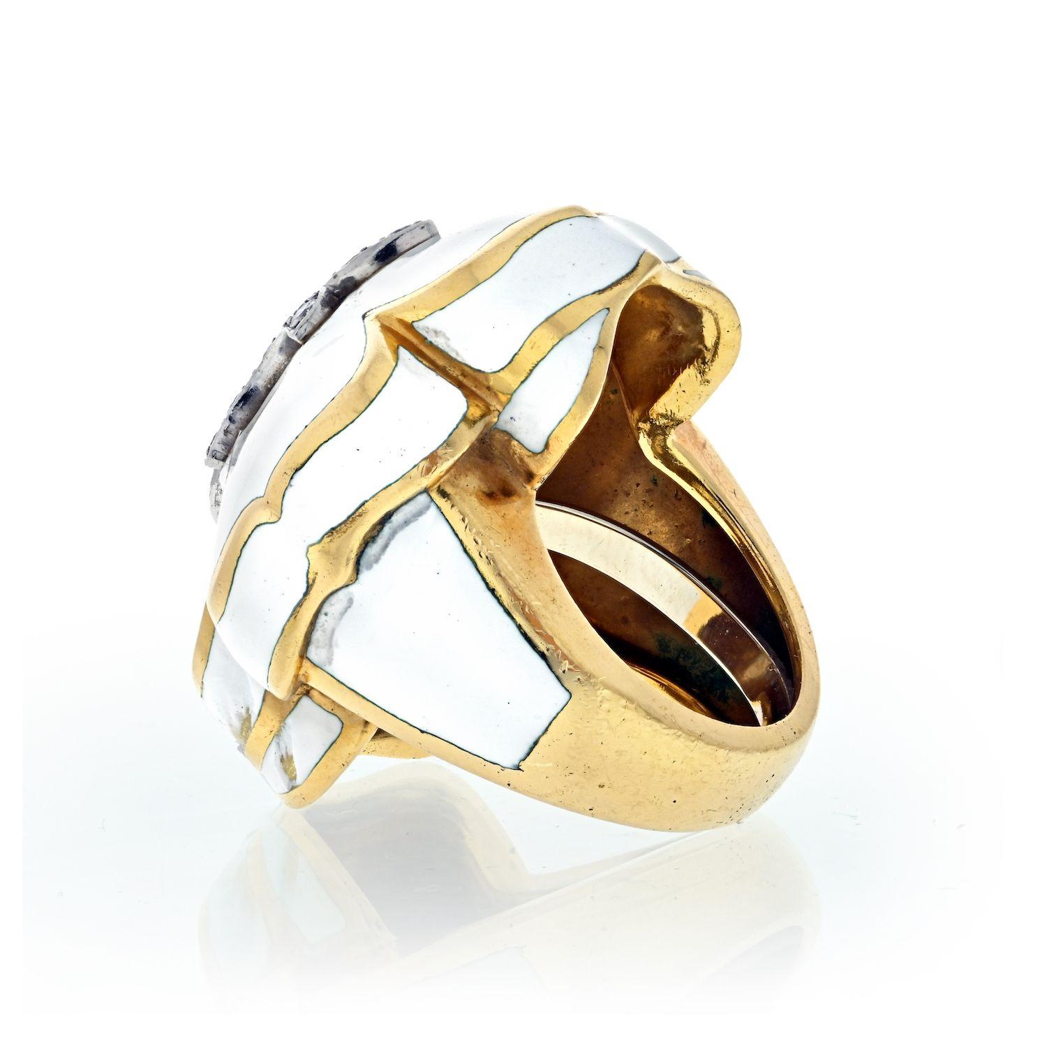 A statement cocktail ring made in 18K Yellow Gold with Fleur de Lis Motif ring by David Webb.
Featuring 0.75 Carats of Round Brilliant Diamonds.
White Enamel.
Measurements: Band Width 12.7mm, Ornament Width 26.1mm, Ornament Length 32.7mm. Ring size