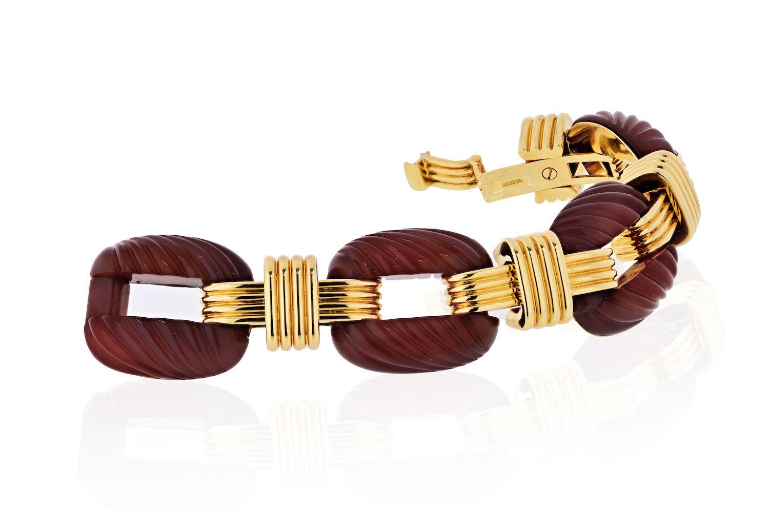 Important carnelian link bracelet by David Webb composed of cushion-shaped fluted carnelian, with open centers, bisected by wide ribbed gold bands
Excellent condition. Carnelian: deep reddish-brown, translucent, good luster.
7.5 inches long. 
