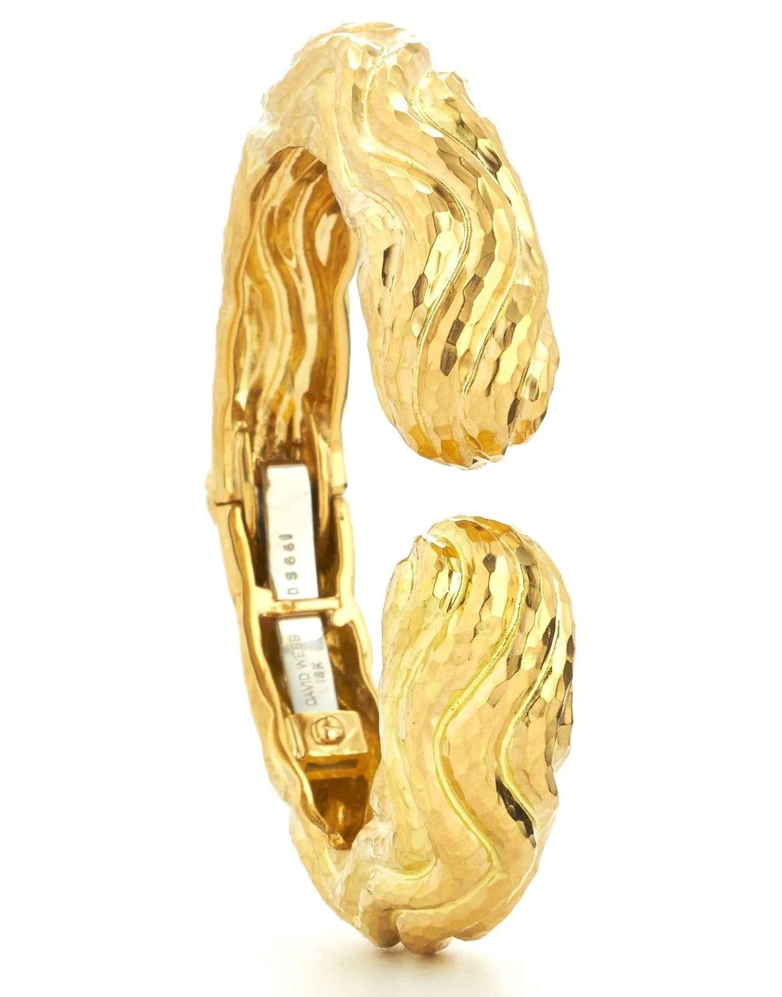 The David Webb Platinum & 18K Yellow Gold Hammered Cuff Wave Bangle Bracelet is a stunning piece of jewelry that showcases the brand's iconic style and exceptional craftsmanship. Crafted in 18K yellow gold, this cuff bracelet features a unique wave