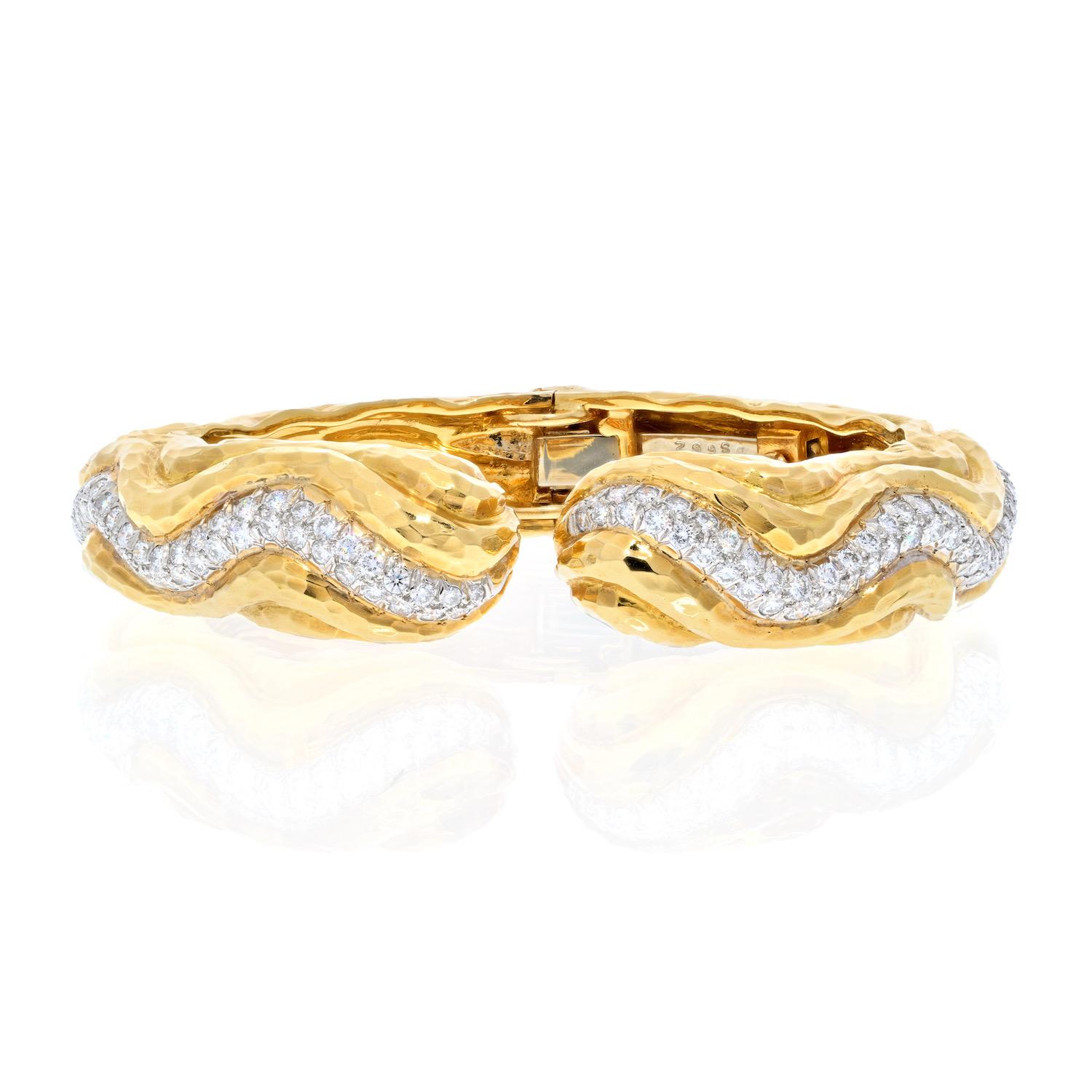 David Webb 18k gold and platinum wave bracelet, set with approx. 1.80ctw in H/VS diamonds. Bracelet will fit approx. 6.5 wrist and is 15mm wide. Weight is 69 grams. 
Marked David Webb, 18k, 900pt. 
Excellent condition, fun stackable item for your