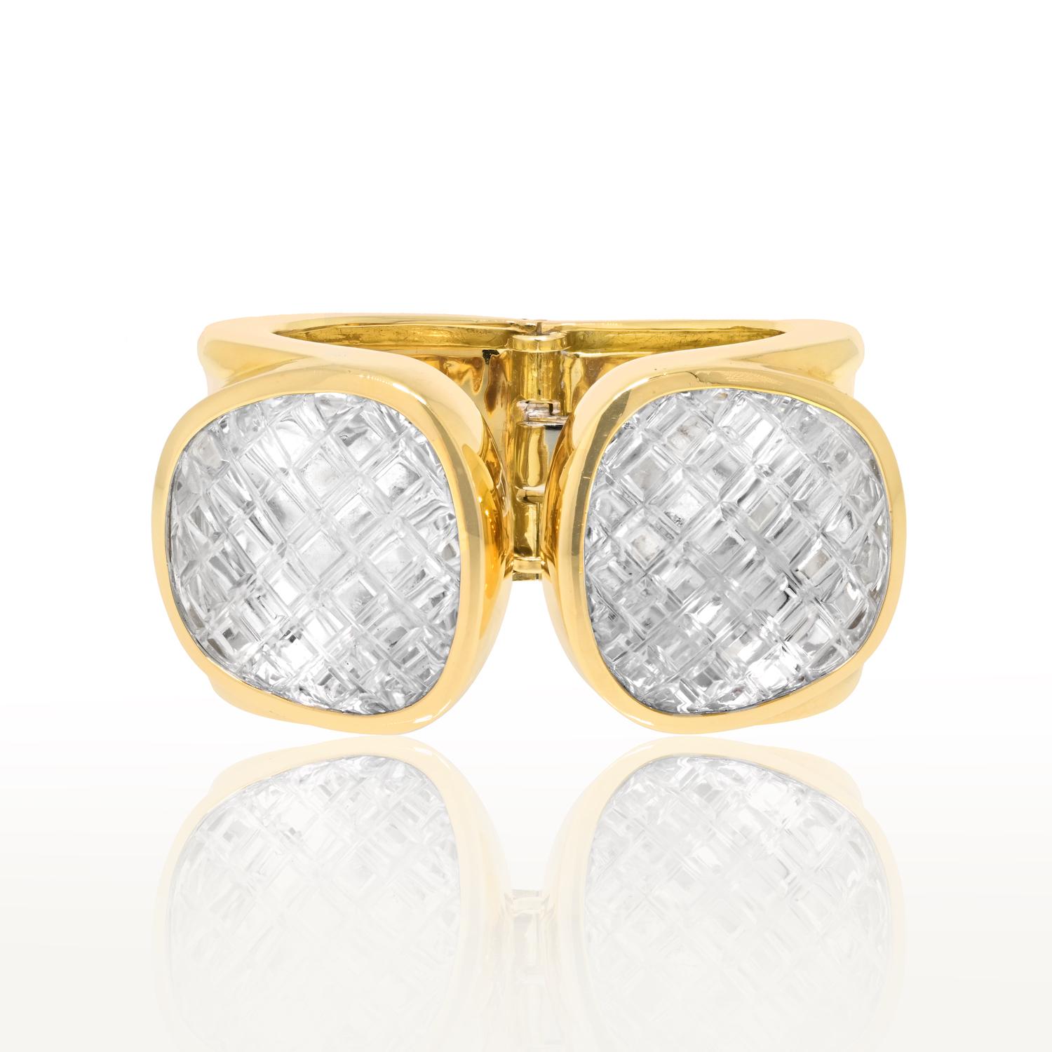 Immerse yourself in the opulence of this Estate David Webb Yellow Gold Crystal Cuff – a masterpiece that seamlessly combines artistry and luxury. 

Created by the renowned David Webb, this cuff features two modified cushion-shaped, cross-hatch