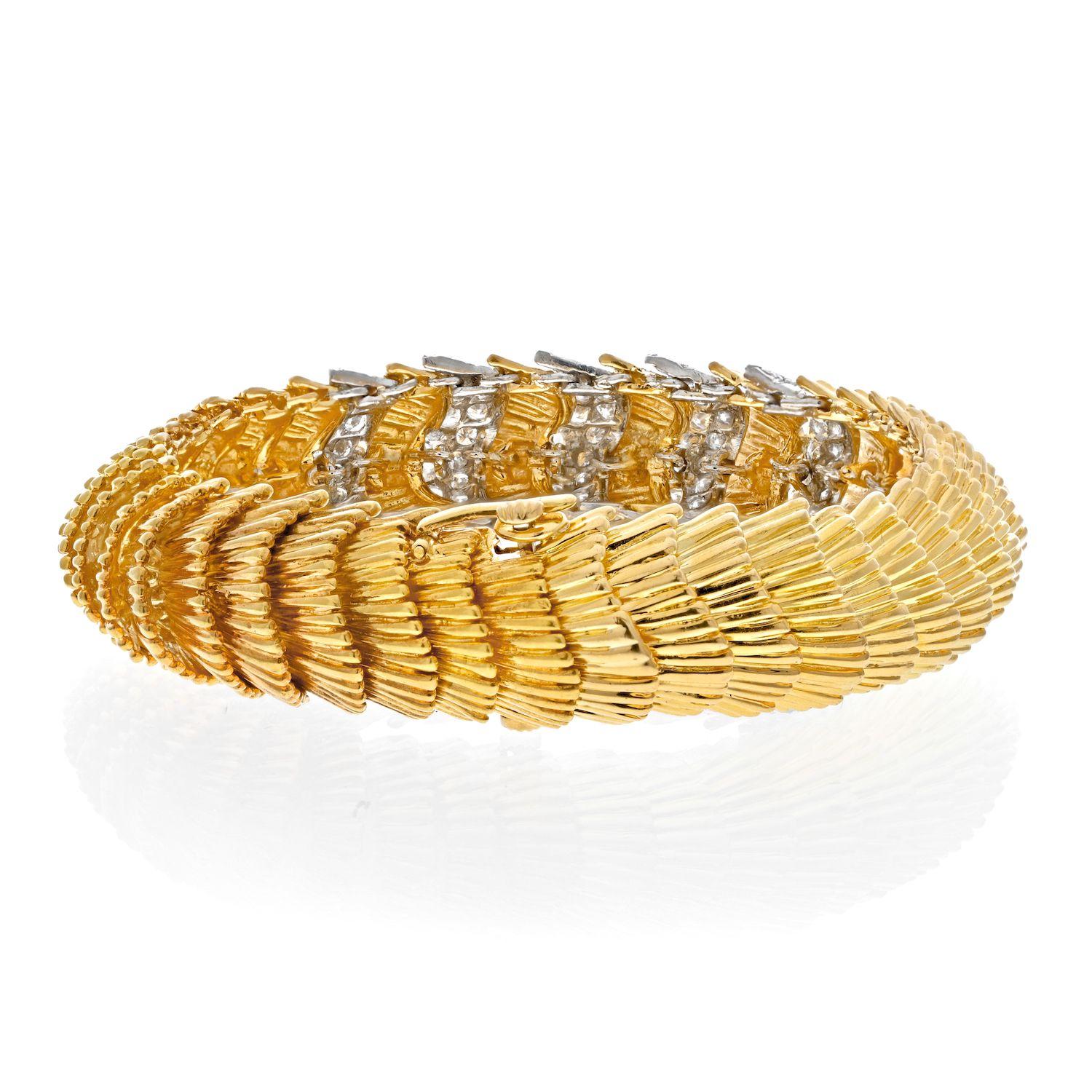 A vintage bracelet by David Webb crafted in 18 karat gold comprised of flexible rows of intricate featherlike links. The ridged links a smooth to the touch, with five links containing round brilliant cut diamonds weighing approximately 5.75 carats
