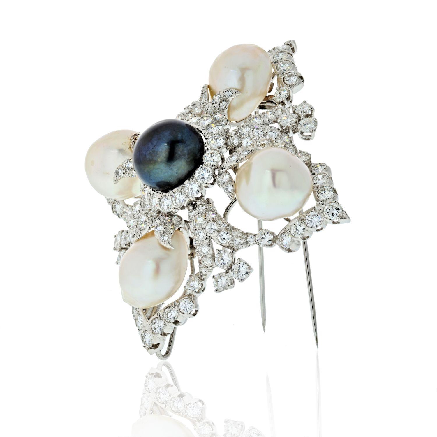 Clip-broche David Webb en platine, perle de culture baroque noire et des mers du Sud et diamant en forme de croix de Malte. 
Centrant une perle noire ap. 15.0 mm, entourée de 16 diamants ronds, divisée en quatre par 4 perles blanches d'ap. 15.6 à
