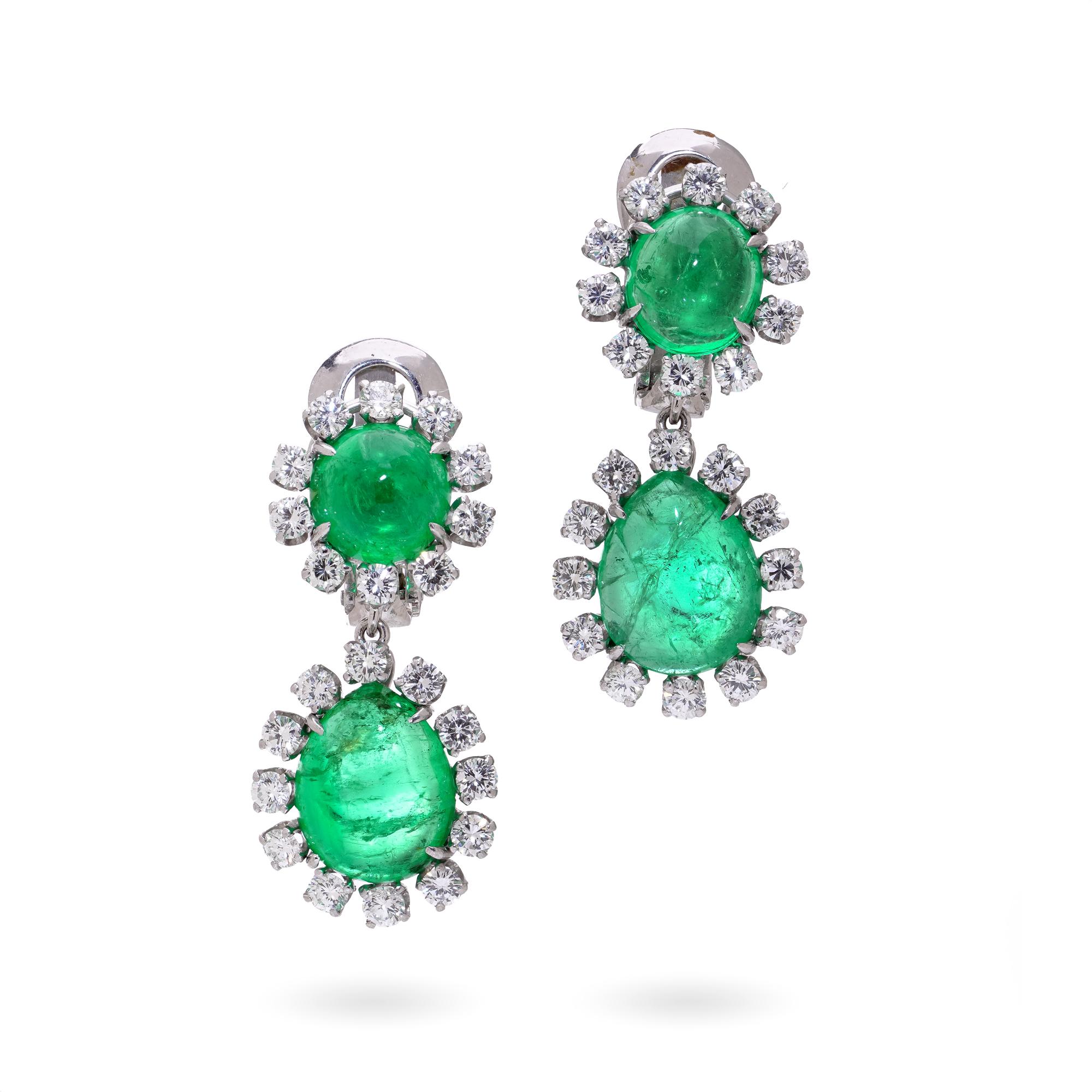 Une exquise paire de boucles d'oreilles David Webb en platine présentant des émeraudes colombiennes en cabochon entourées de diamants taillés en brillant. Chaque boucle d'oreille est composée d'une petite émeraude ronde au-dessus d'une plus grande