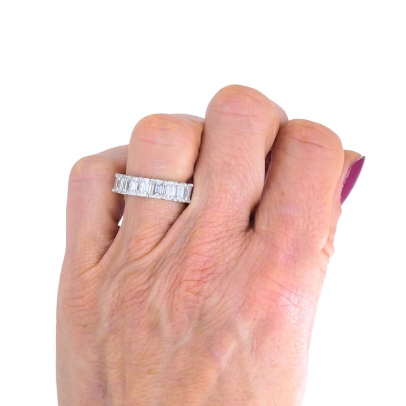 A David Webb platinum ring that is designed as a diamond eternity band. Crafted from polished platinum, the band is set with a continuous row of baguette cut diamonds. Each diamond is cut to showcase its clarity. The baguette cut adds a sleek,
