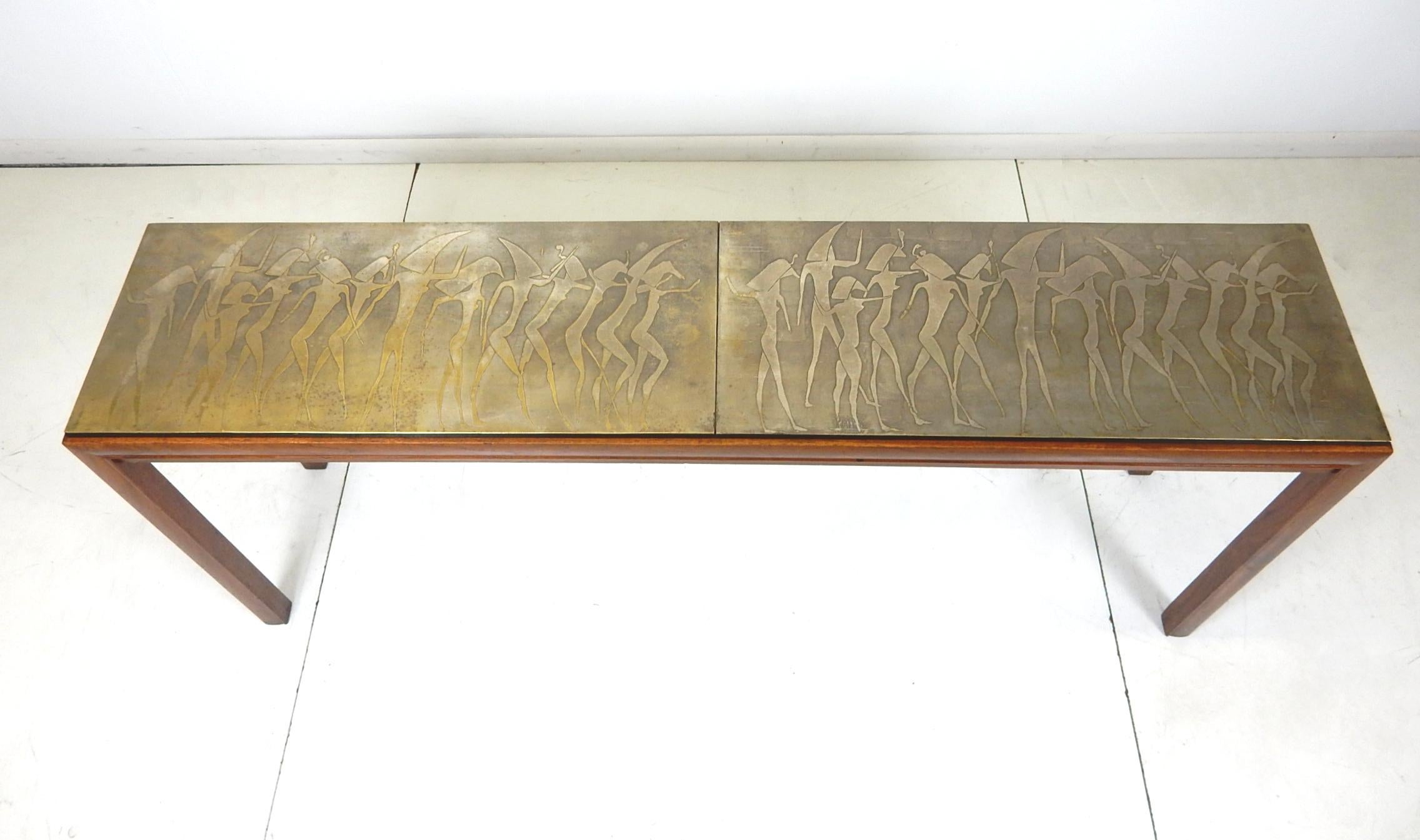 Incredible and unique art console table, circa 1970s.
Constructed in a Parson style of solid walnut with a raised centre trimmed in black acrylic
and topped with thin bronze sheet depicting frolicking surreal female nudes.
Perfect foyer