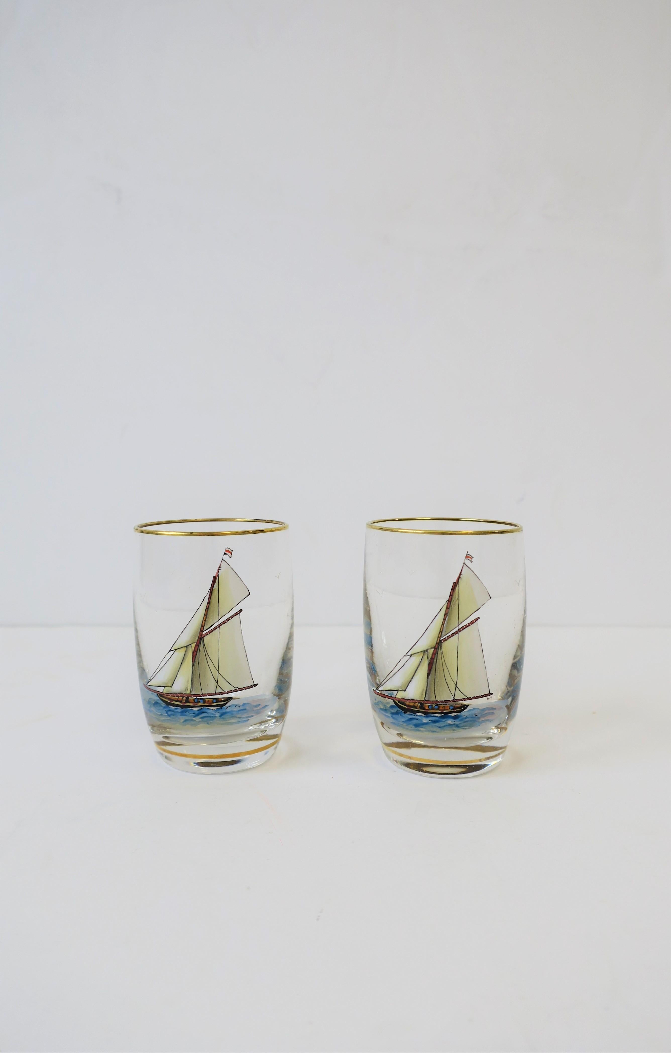 A beautiful set of two crystal aperitif or shot glasses with mini nautical art scene of large sailboat, ocean sea, and seagull birds. Glass rim and base have gold detail. Excellent condition. 

Each measure: 2.50 in. H.