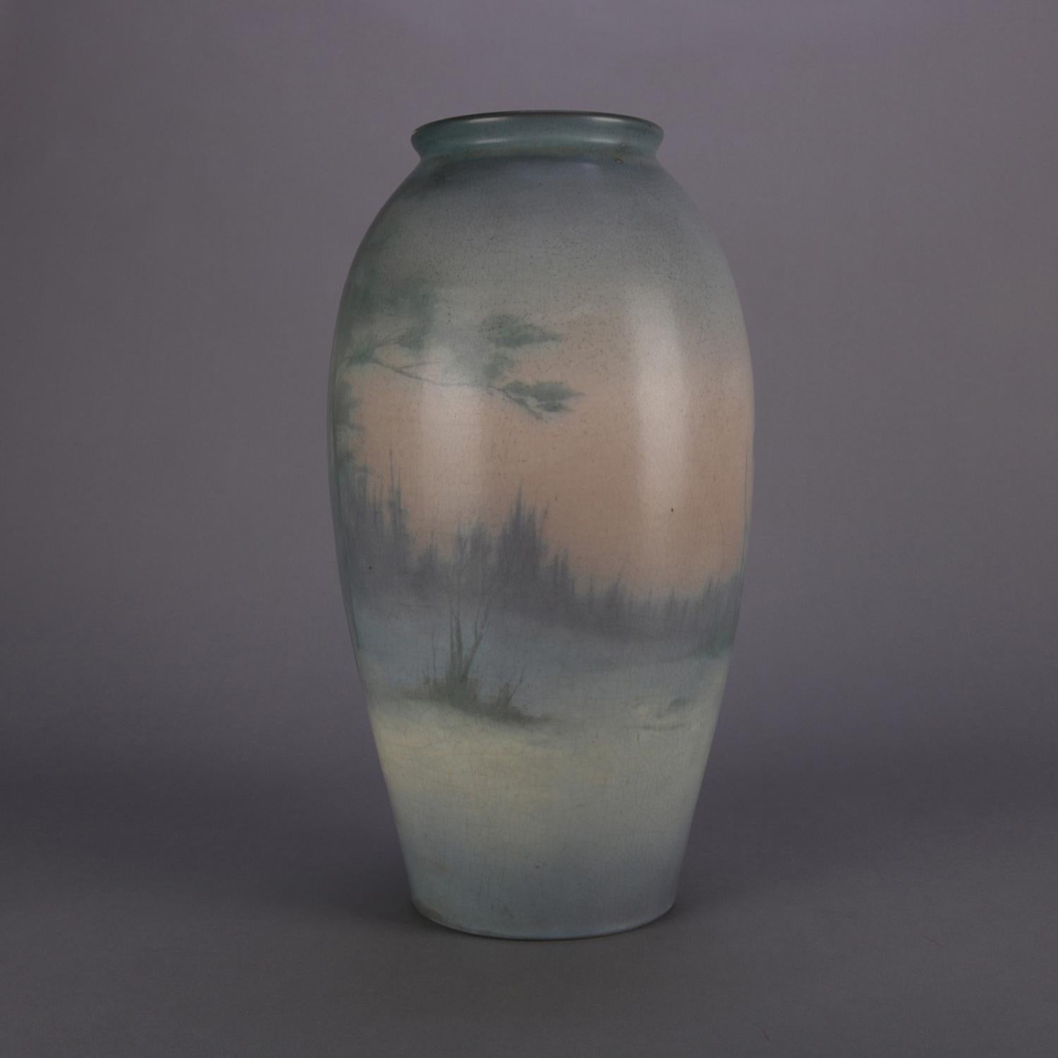 Antique oversized art pottery vase by Rookwood features hand-painted forest landscape scene beneath velum glaze, signed on base, c1916

Measures: 16