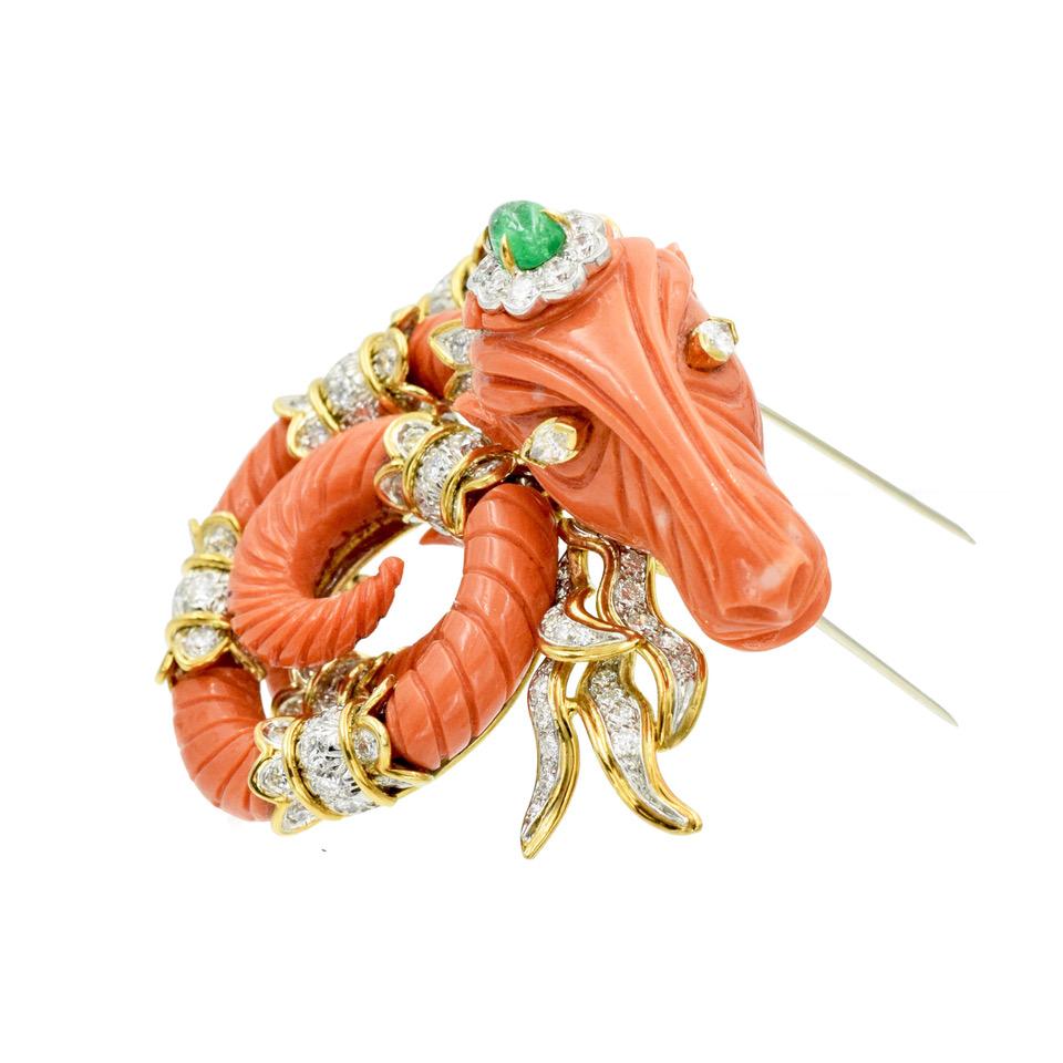David Webb Coral, Diamond and Emerald Ram Brooch 18K Yellow Gold and Platinum.

This exquisite brooch features carved coral ram's head, with marquise-cut diamond eyes. Adorned with round brilliant cut diamonds and oval shape cabochon cut emerald