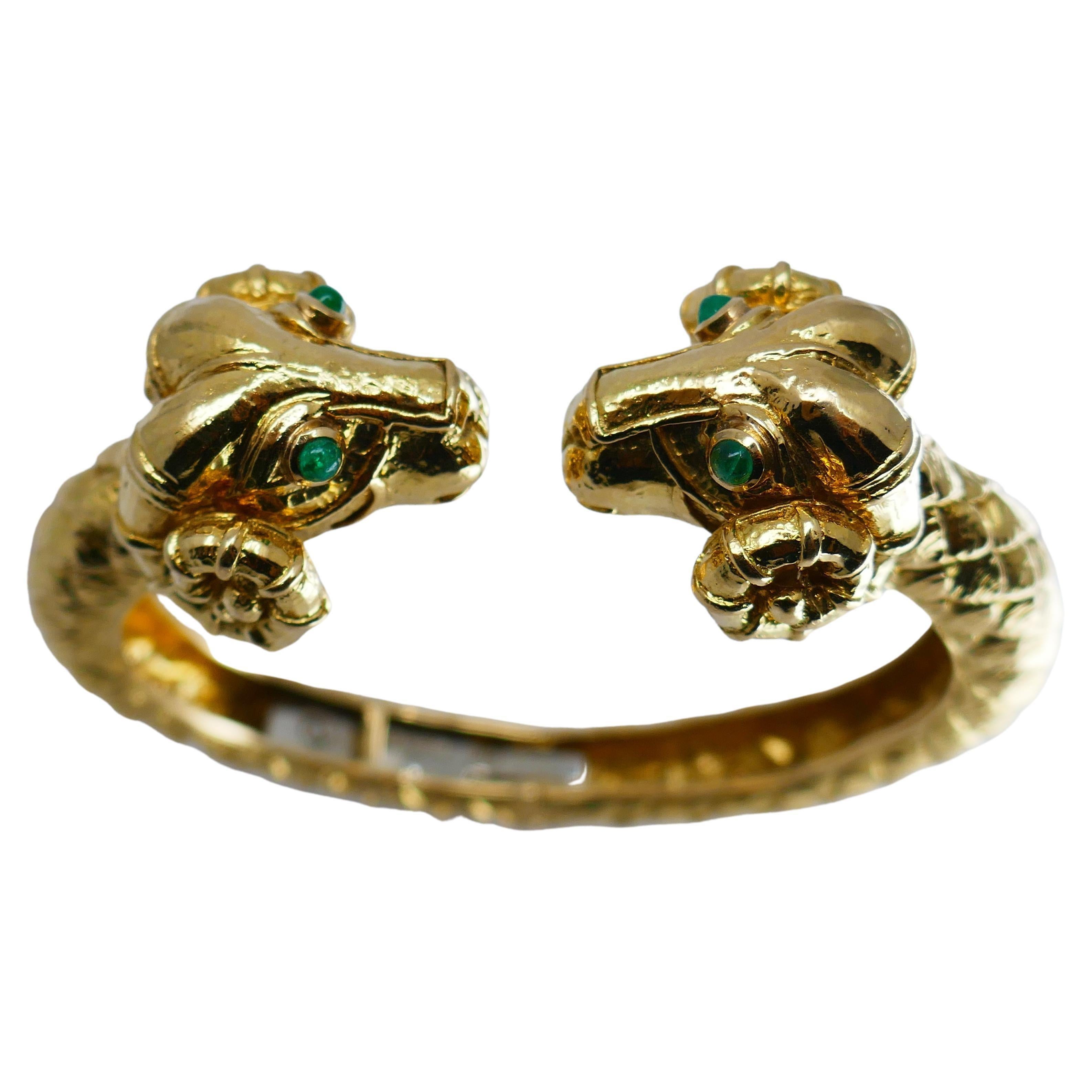 A hinged cuff bracelet by David Webb, made of 18k gold, features emerald.
The bracelet designed as two ram heads facing each other. The rams can be interpreted as Aries astrological sign. The emerald is cabochon cut.

About David Webb 
Bold,