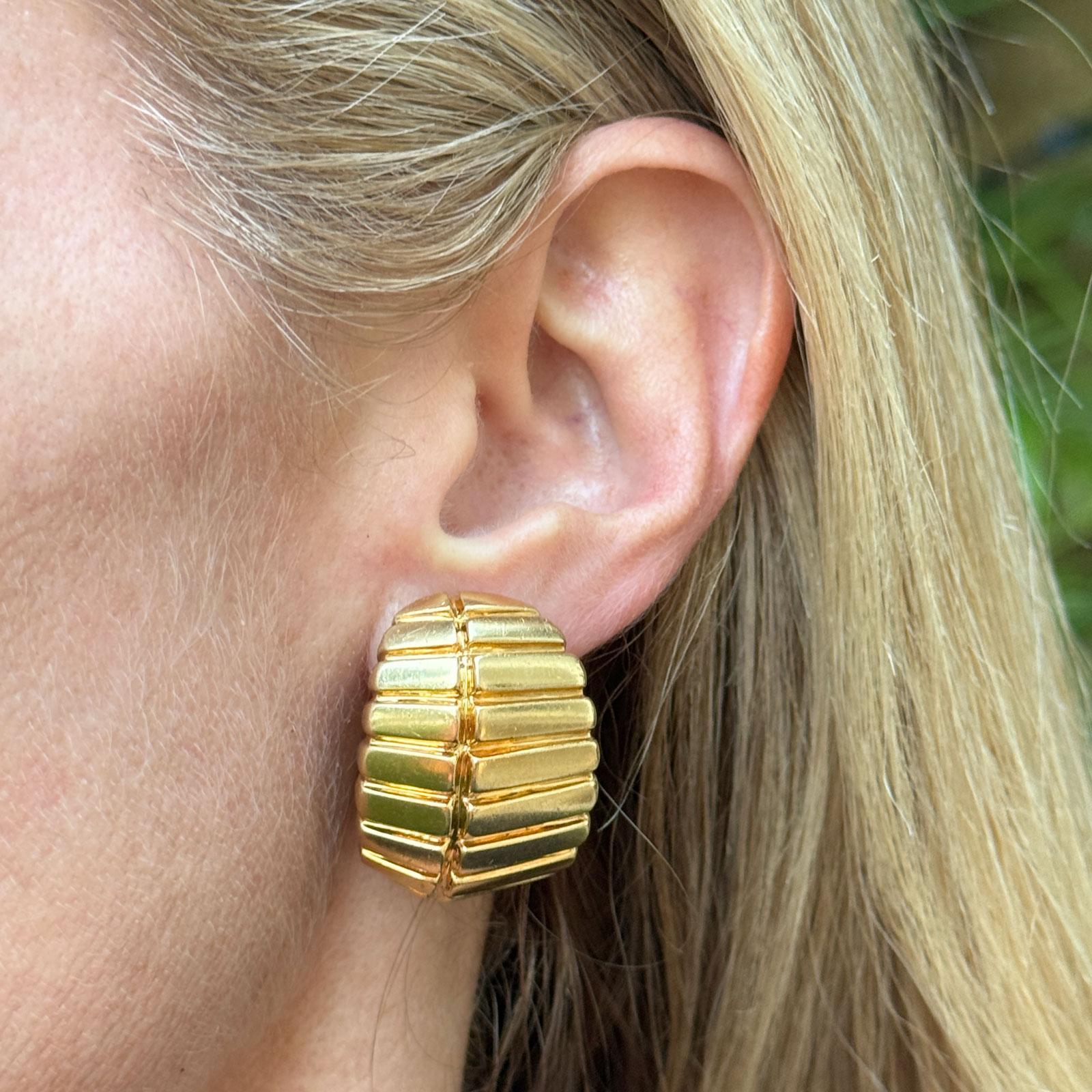 These contemporary 18-karat yellow gold earclip earrings by David Webb feature a bold and elegant ribbed design. Measuring approximately 0.90 x 1.10 inches, they showcase Webb's signature sculptural craftsmanship, with ribbed design adding texture