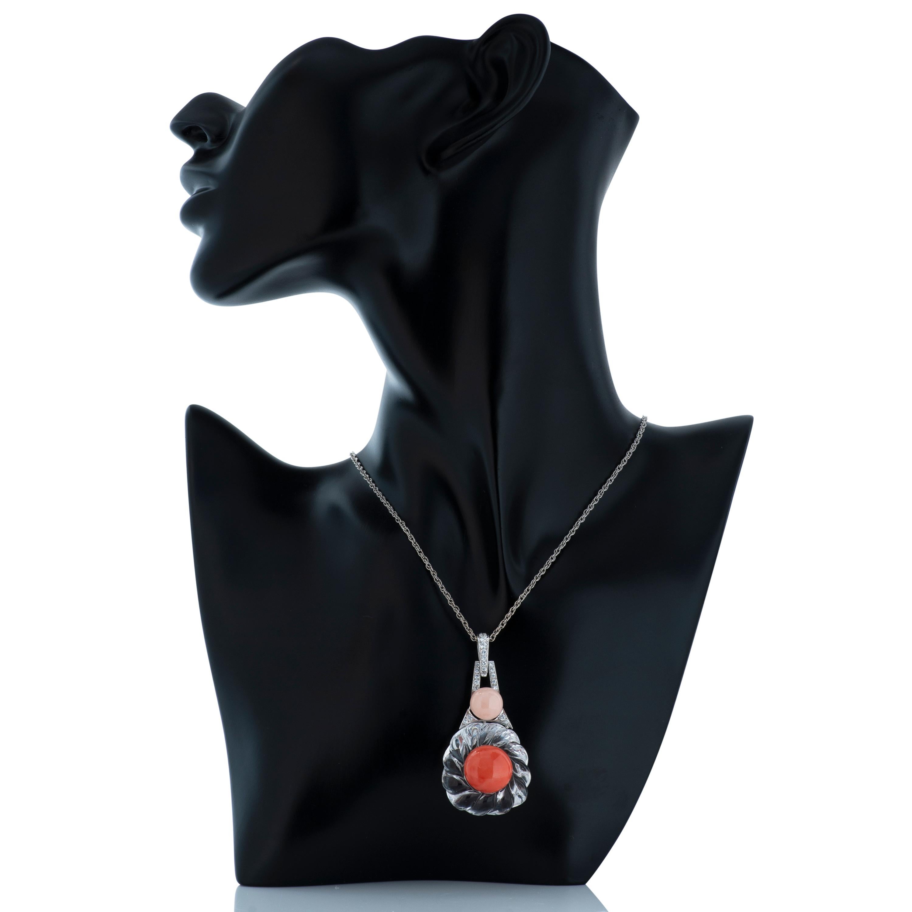 David Webb carved rock crystal, coral, angelskin coral and diamond pendant set in platinum and 14k white gold, on an 18k white gold chain.  The base of this pendant is carved rock crystal accented by one piece of round cabochon angelskin coral, one