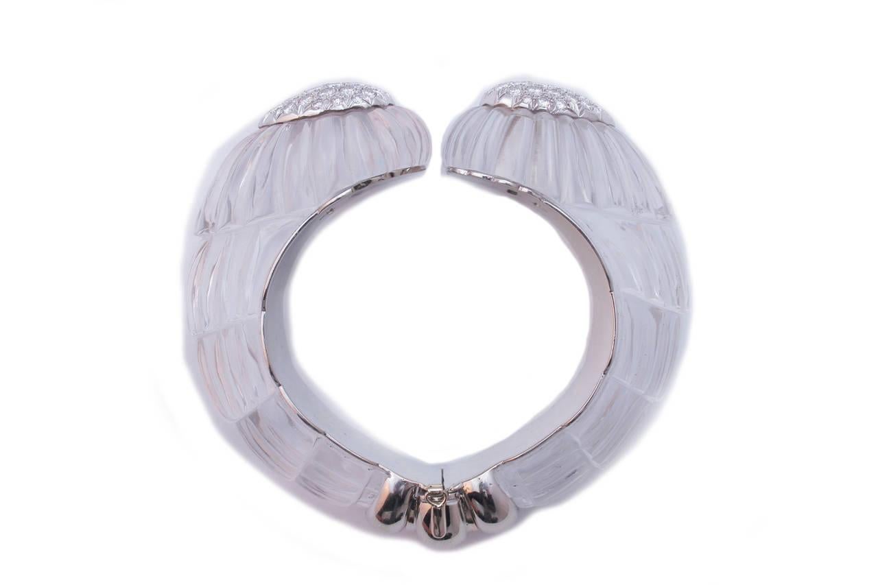 Un raro bracciale del designer americano per eccellenza David Webb, che presenta due grandi elementi di finissimo cristallo di rocca intagliati in forme ondulate e impreziositi, sulle loro corone, da un pavé di raffinati diamanti taglio brillante.