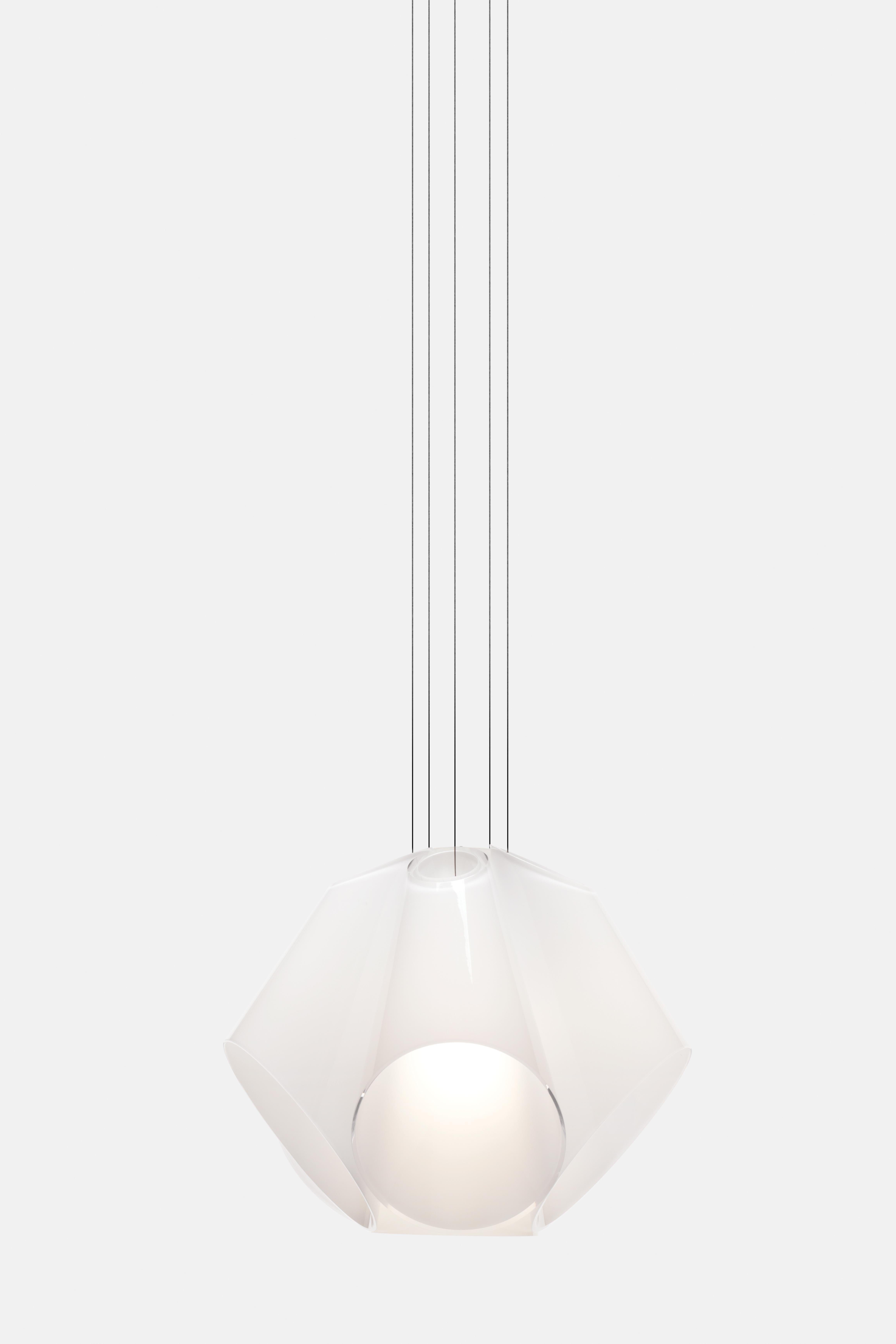 Le luminaire suspendu Super Conic révèle non seulement les détails de la zone qu'il éclaire, mais il ajoute également sa propre beauté délicate à son environnement. Constitué d'un bouquet de cônes en verre blanc disposés autour d'un cône diffuseur
