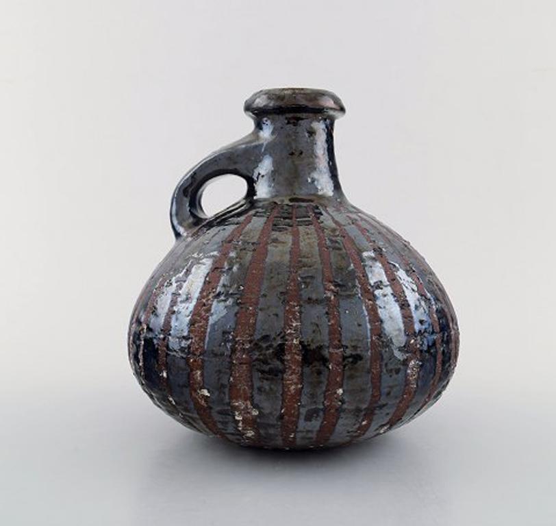 Gutte Eriksen own workshop, pottery pitcher.
Metallic glaze, raku burned.
Stamped. Denmark, 1960s.
Measures: 15.5 cm. x 15.5 cm.
Good condition, few small glaze defects from the production.