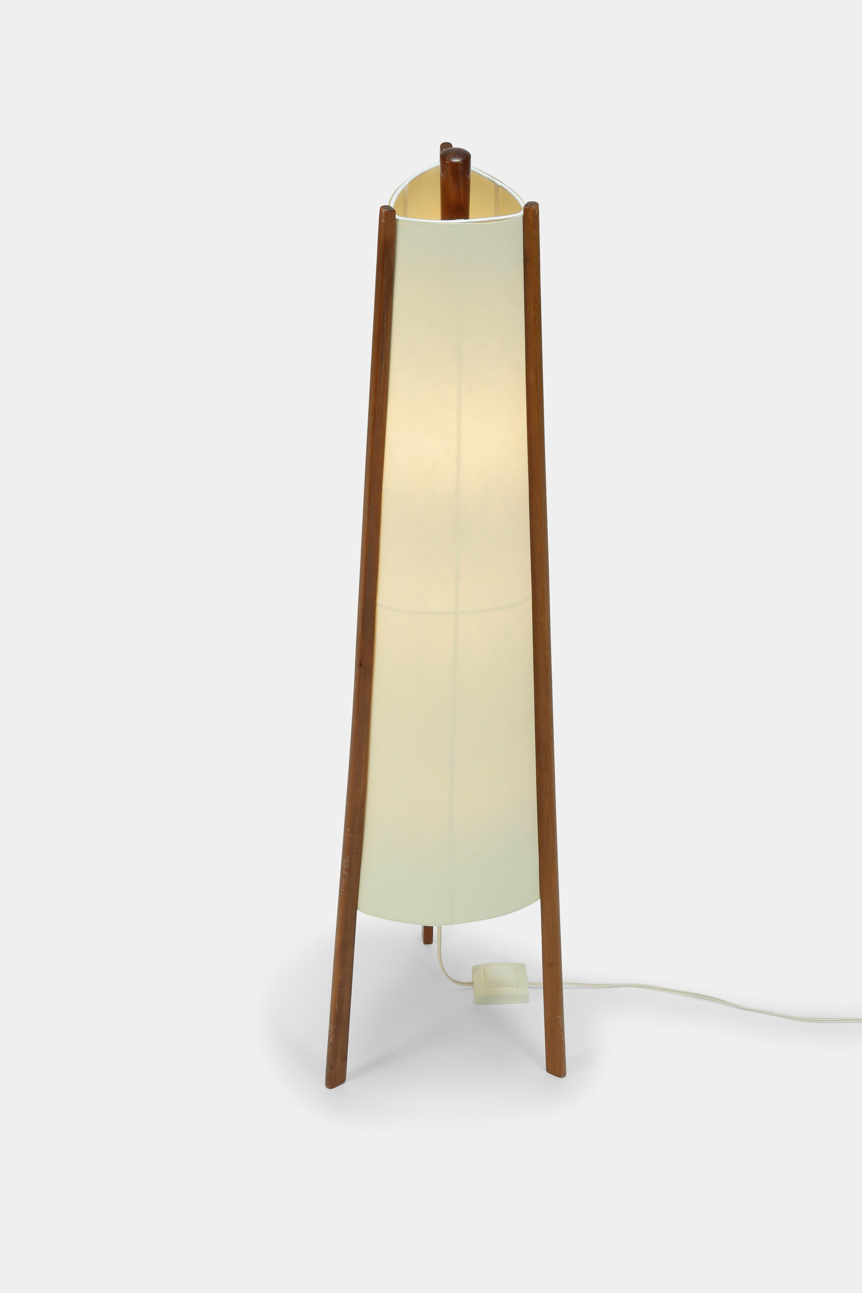 Swiss floor lamp manufactured in the 1950s. New parchment lamp shade attached to three pillars made of solid walnut wood. Generates a pleasant and warm atmosphere.
 