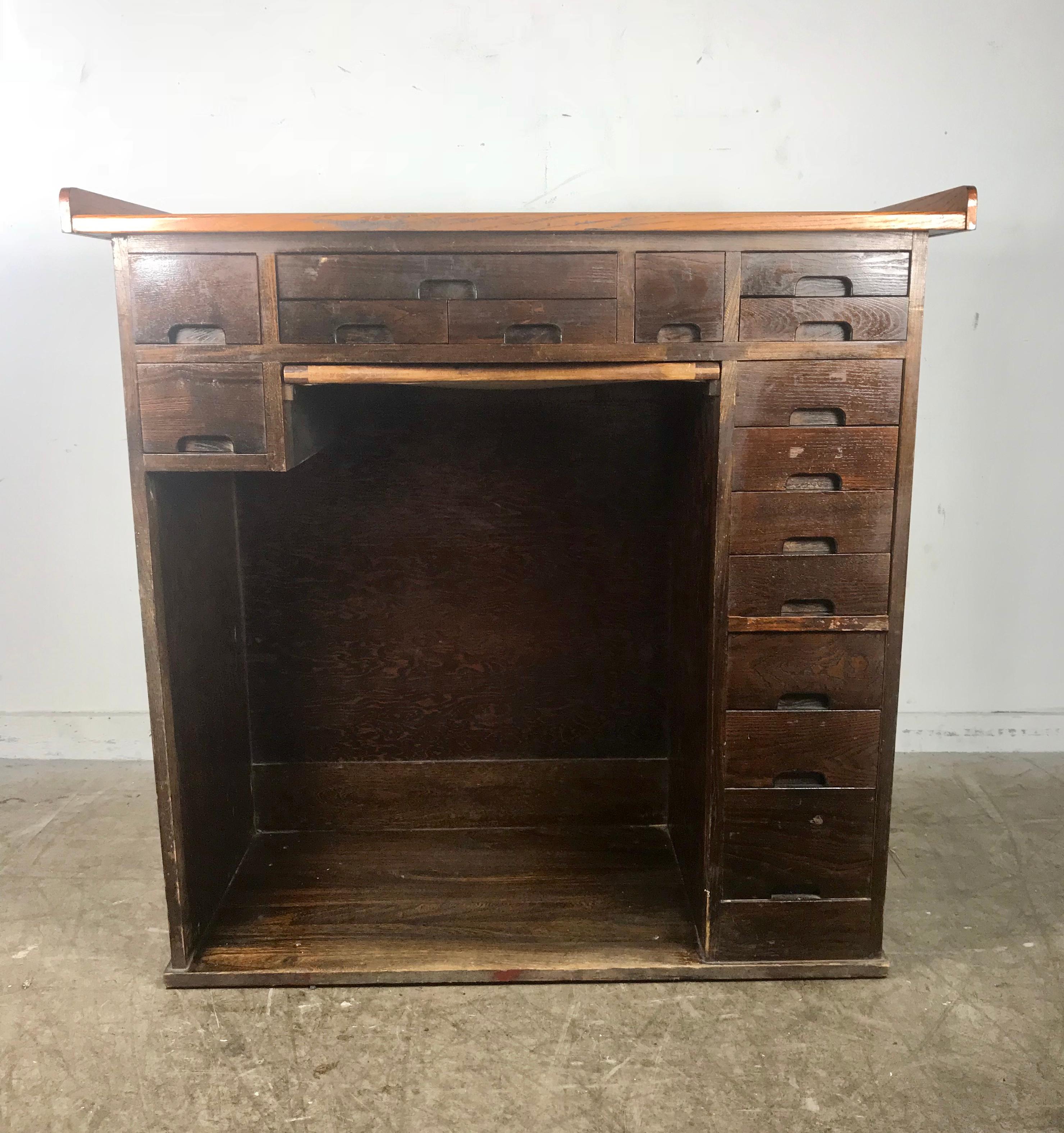 Antique oak multi-drawer jewelers desk, watchmakers work bench by J.H. Rosberg manufacturing co, paneled sides and back, kneehole below three drawer over pull out catch tray with bottom cloth, right side. Nine-drawer, work surface with stains and