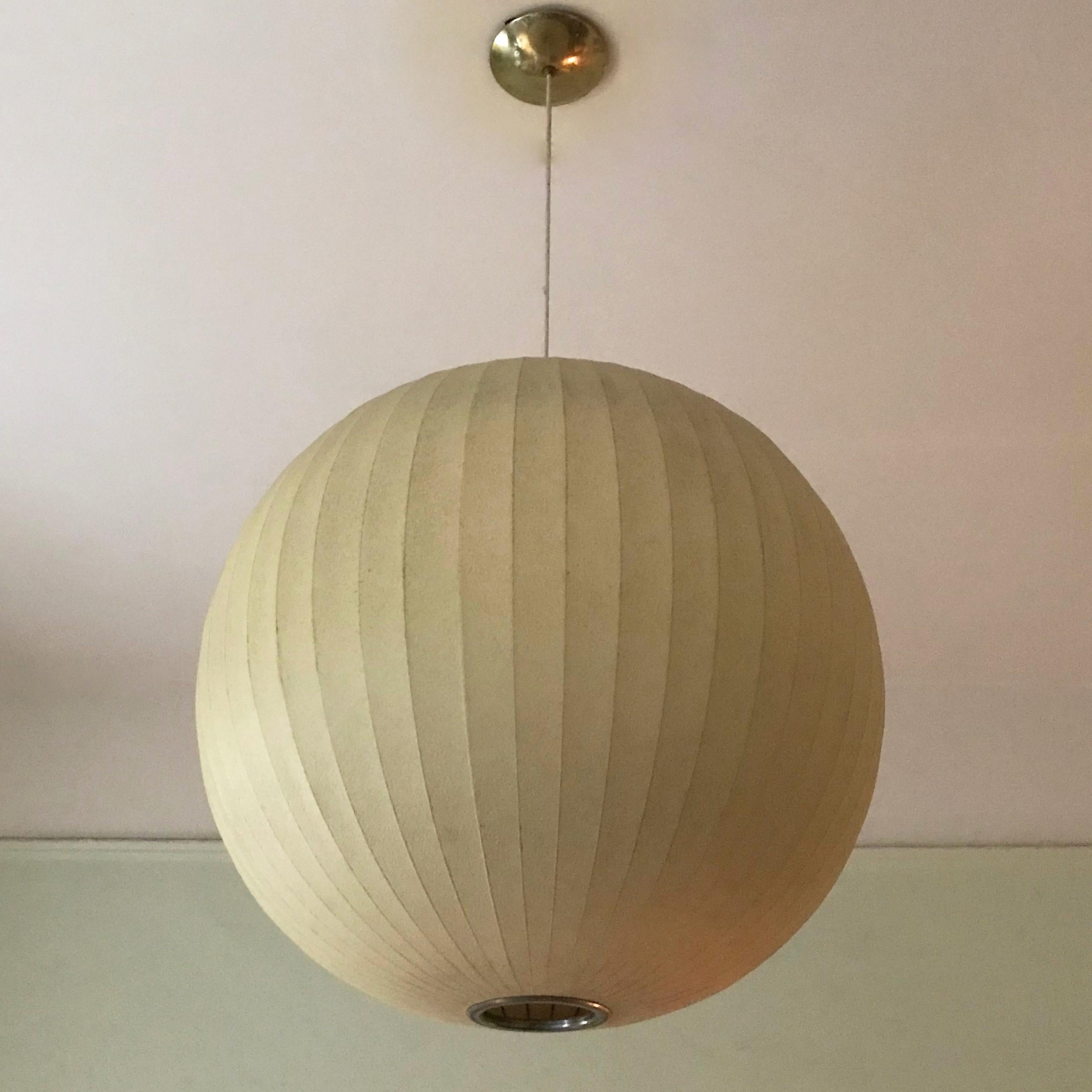 Original, 1950s, George Nelson for Herman Miller pendant light features an impressively oversized fiberglass sphere shade with steel frame and canopy. The pendant emits a warm glow and can accept up to a 200 watt bulb. The full height is 48