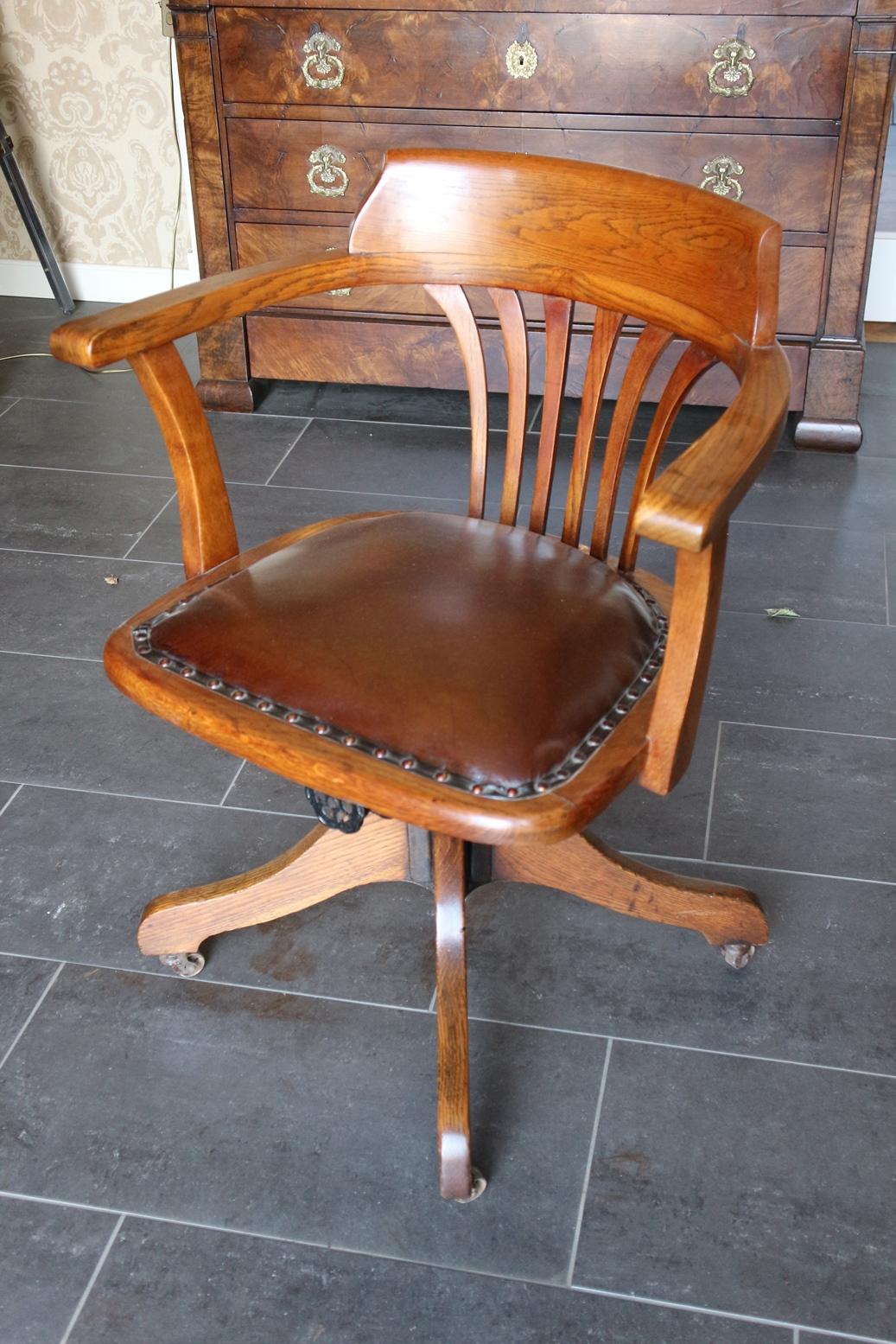 Antique oak office chair in original condition. The chair has seat-height adjustment and a rocking mechanism. Can be equipped with smooth rolling casters, especially for parquet flooring, instead of the original iron casters that are on now.