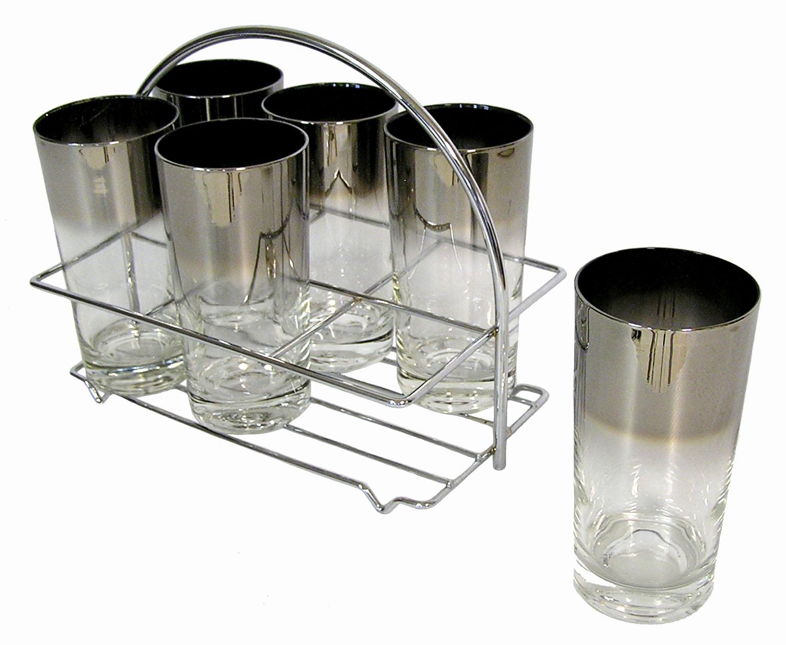 A set of six Dorothy Thorpe silver fade 12 ounce highball glasses from the 1960s Mid-Century Modern era. Set is decorated along the upper half in a faded silver tint and comes in it's original chromed steel carrier. Overall excellent condition.