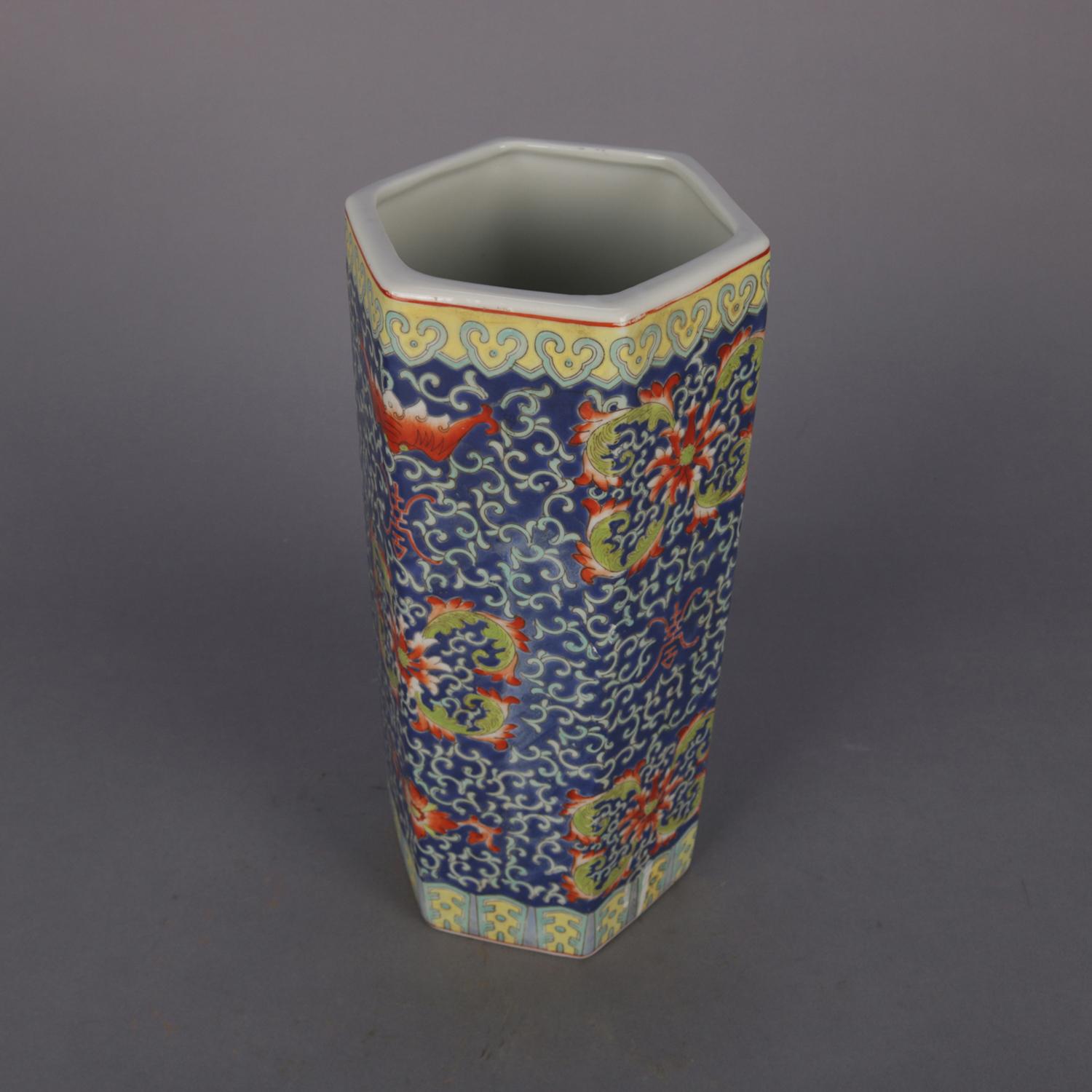 Chinese enameled vase flower vase features hexagonal tower form with scroll and foliate motif on blue ground and having paneled collar and base, en verso stamp signed, 20th century.

Measures: 12.5