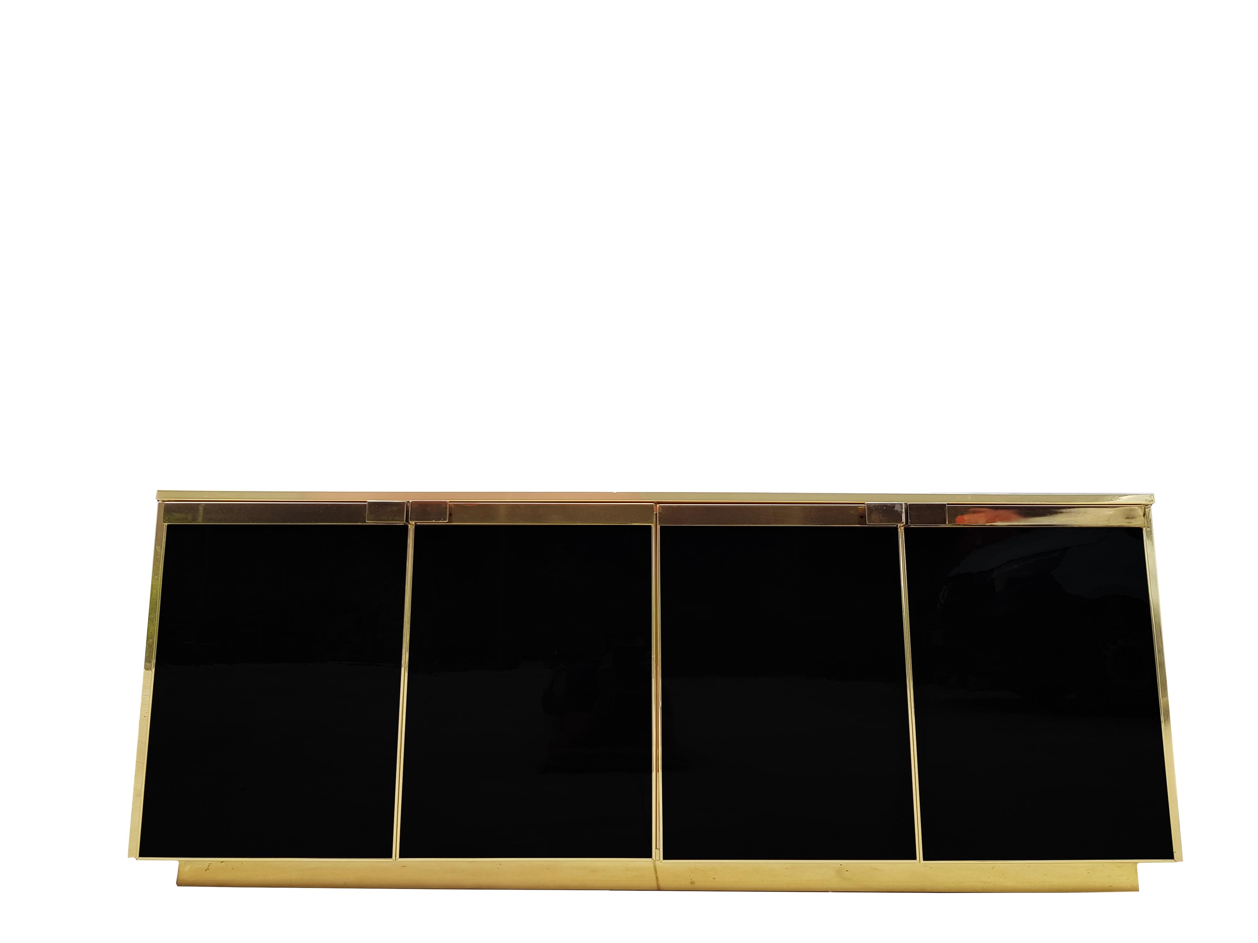 This sideboard from the 1970s is very elegant and has 4 doors with black glass.
The top is also a black glass.
Well finished with brass details.
Maison Jansen style.
    