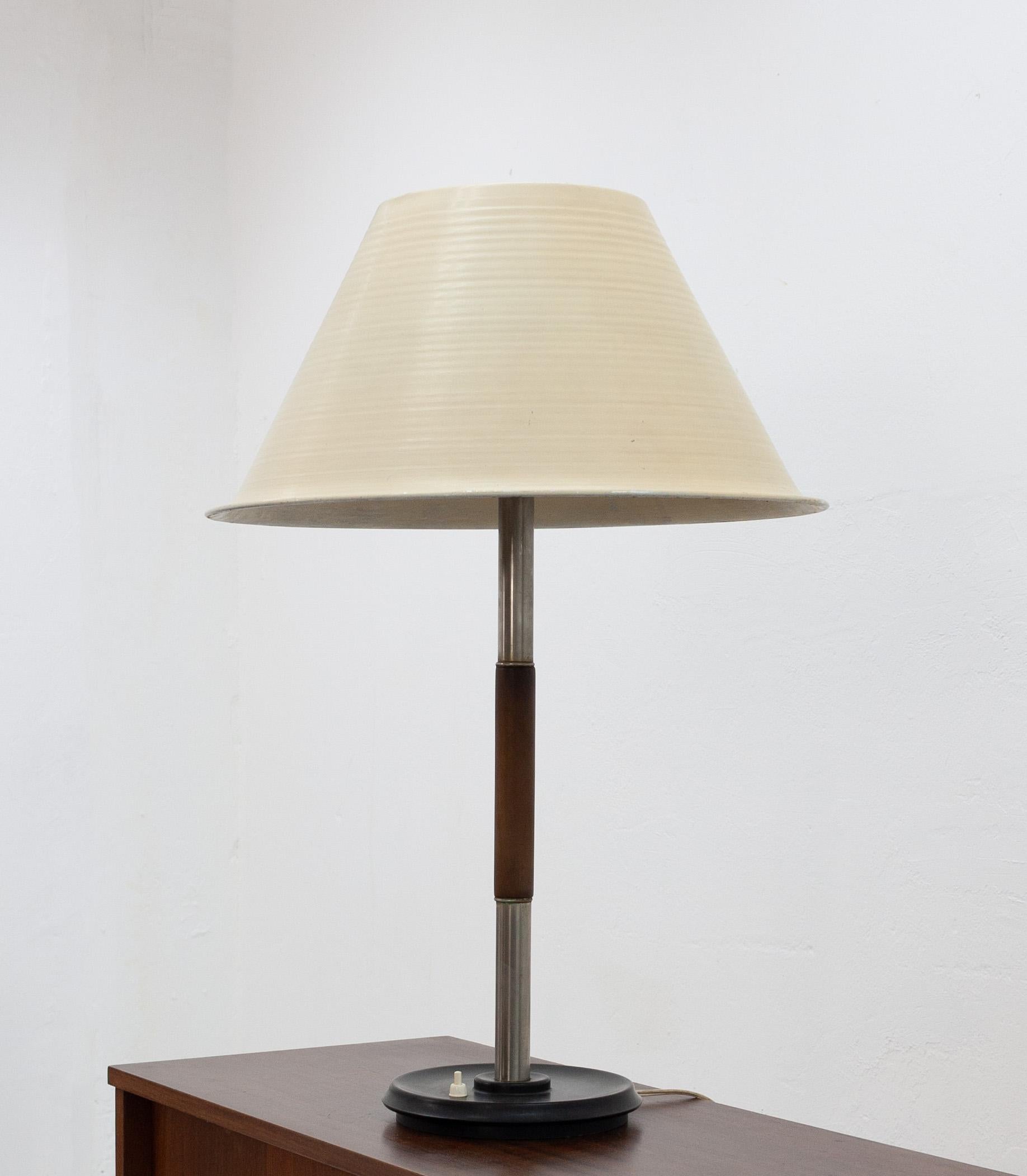 Very rare find this table light by W.H. Gispen. Model Giso 5020, 1947. Features a round bakelite base with push switch, ridged aluminum lampshade and the original glass inner hood. Signed on base. All complete and original.