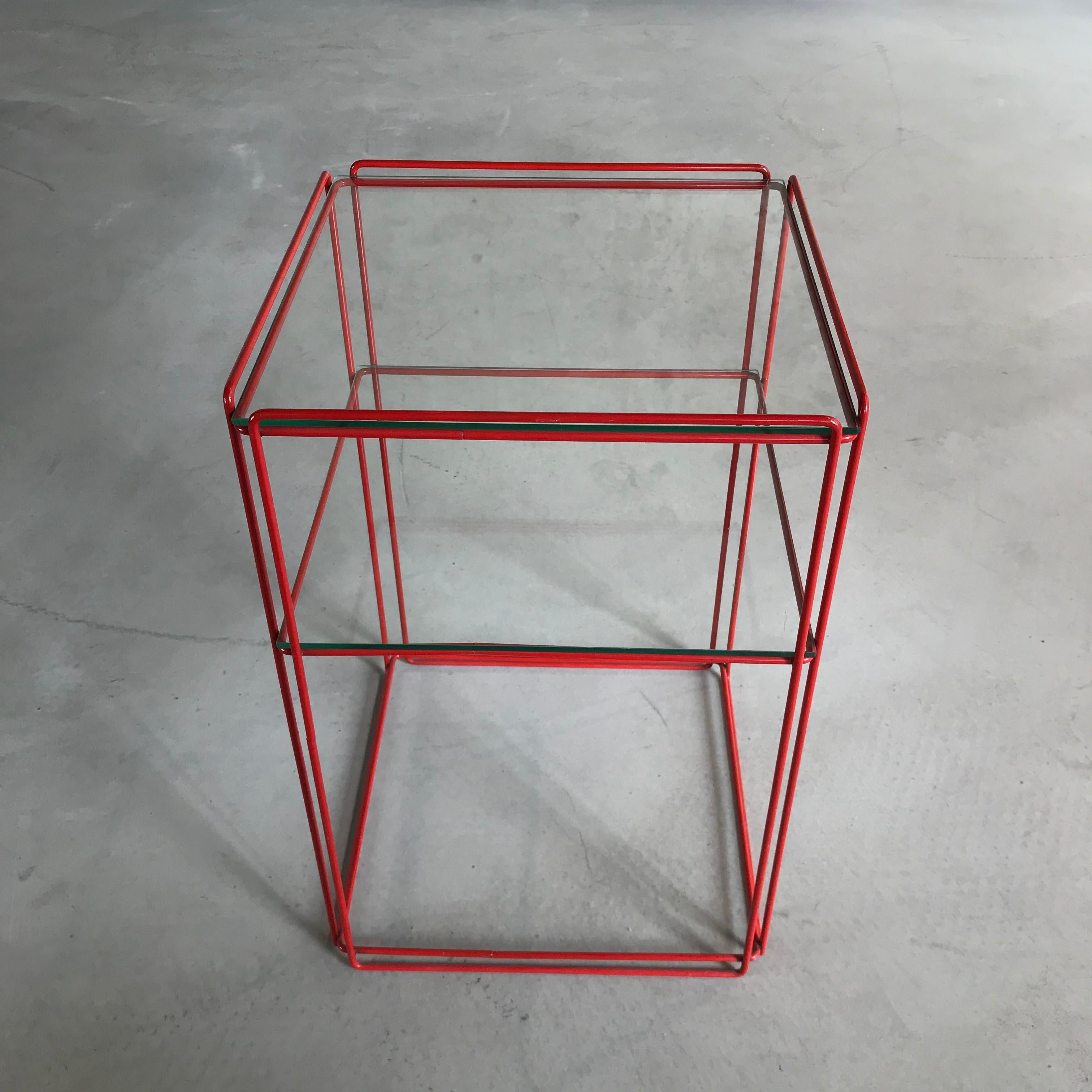 Beautiful, graphical and Minimalist design by Max Sauze for Max Sauze Studio or Atrow, circa 1970. This table features a red colored metal base and two glass 'shelves'. The glass and metal wire structure gives this table a very transparent, minimal