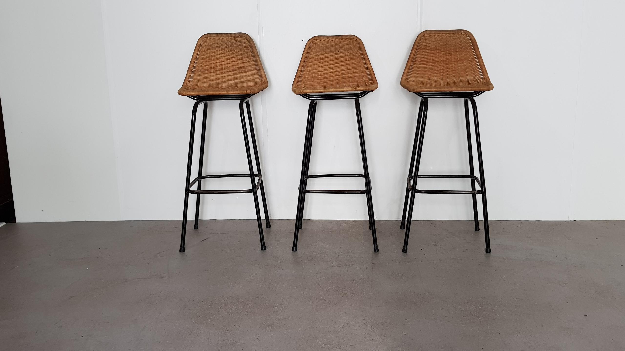 Set of three bar stools by Dirk van Sliedregt for Rohe Noordwolde 

In the style of Charlotte Perriand, rattan seating and black metal frame. Rattan is in good condition, frame has some rust.

Measures: Width 42 cm

Depth 42 cm; seating 31