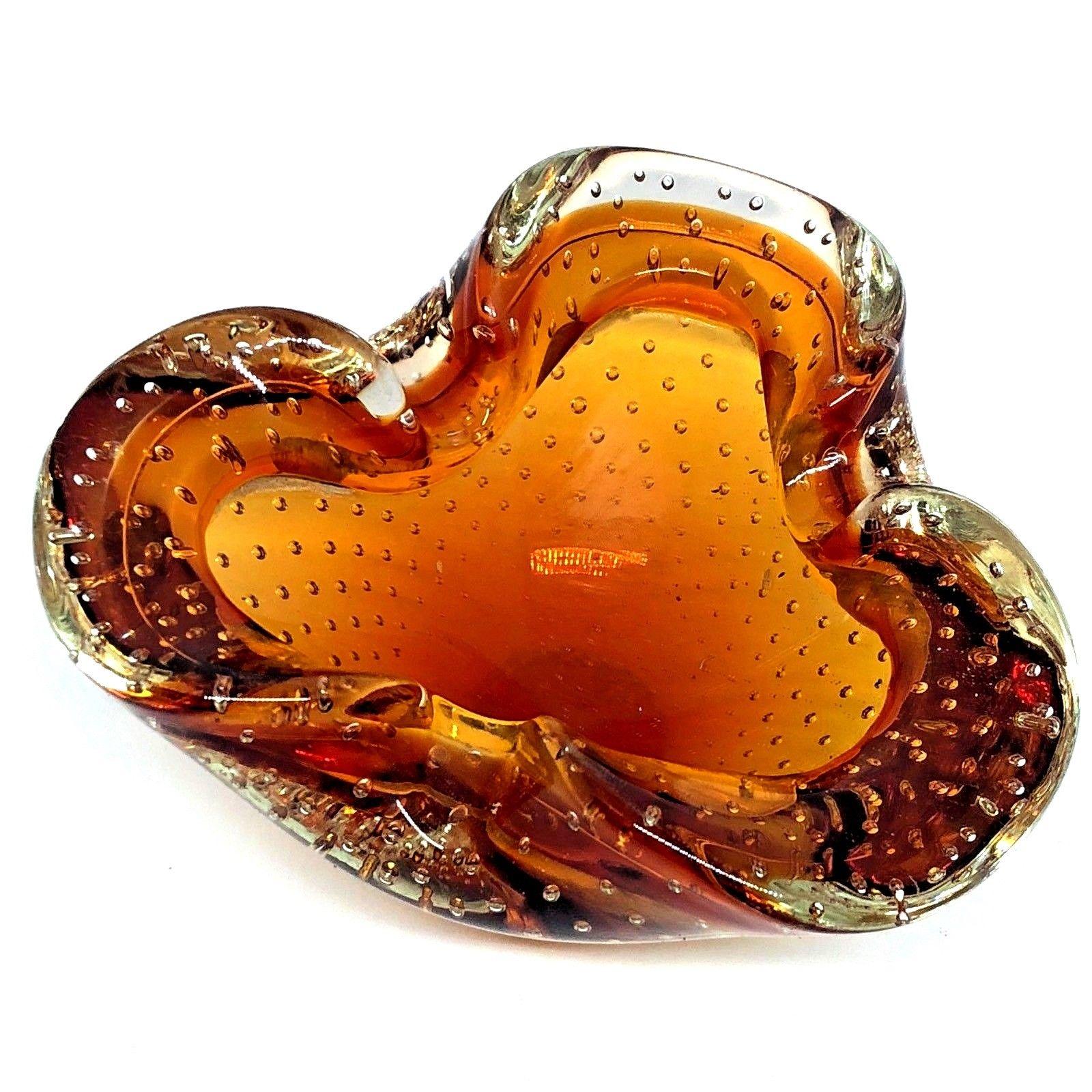 Gorgeous handblown Murano art glass piece with Sommerso and bullicante techniques. A beautiful organic shaped bowl or ashtray in amber glass cased into clear glass and full of blown controlled bubbles, Italy, 1960s.