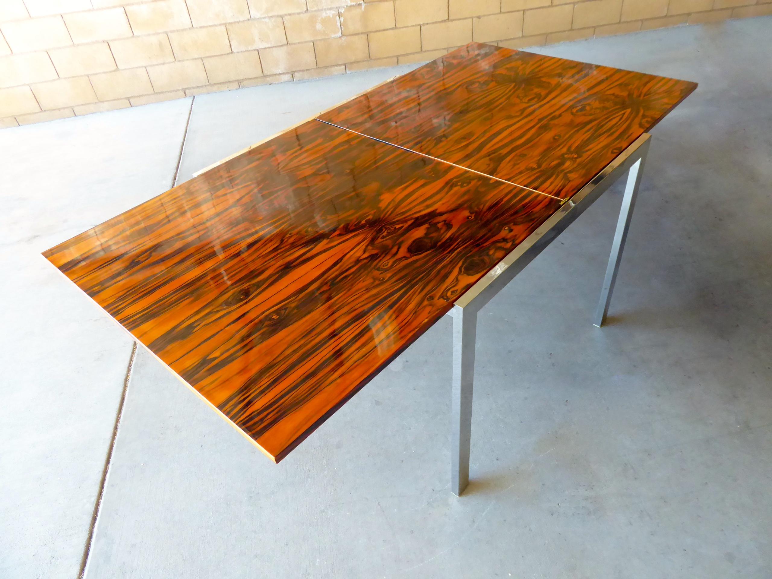 A 1960s chrome-plated steel card table with a Macassar ebony flip-top in the style of Milo Baughman. The top slides within the metal framework and flips open to reveal a wildly grained Macassar ebony surface the will accommodate four to six people.