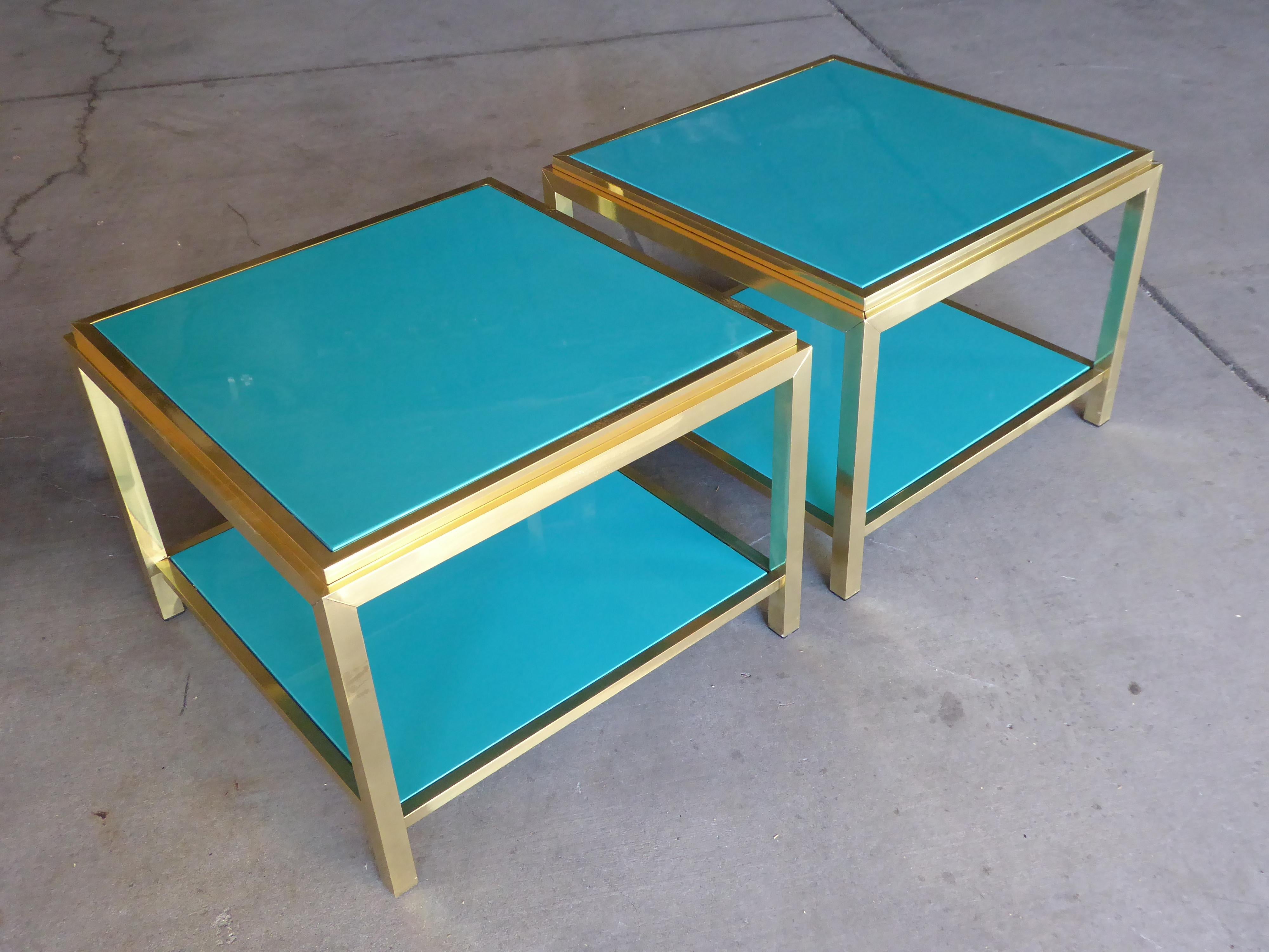 A pair of solid brass two-tier square side table with peacock blue lacquered tops and shelves. The tables are attributed to Mastercraft and the lacquered wood surfaces are recent additions.