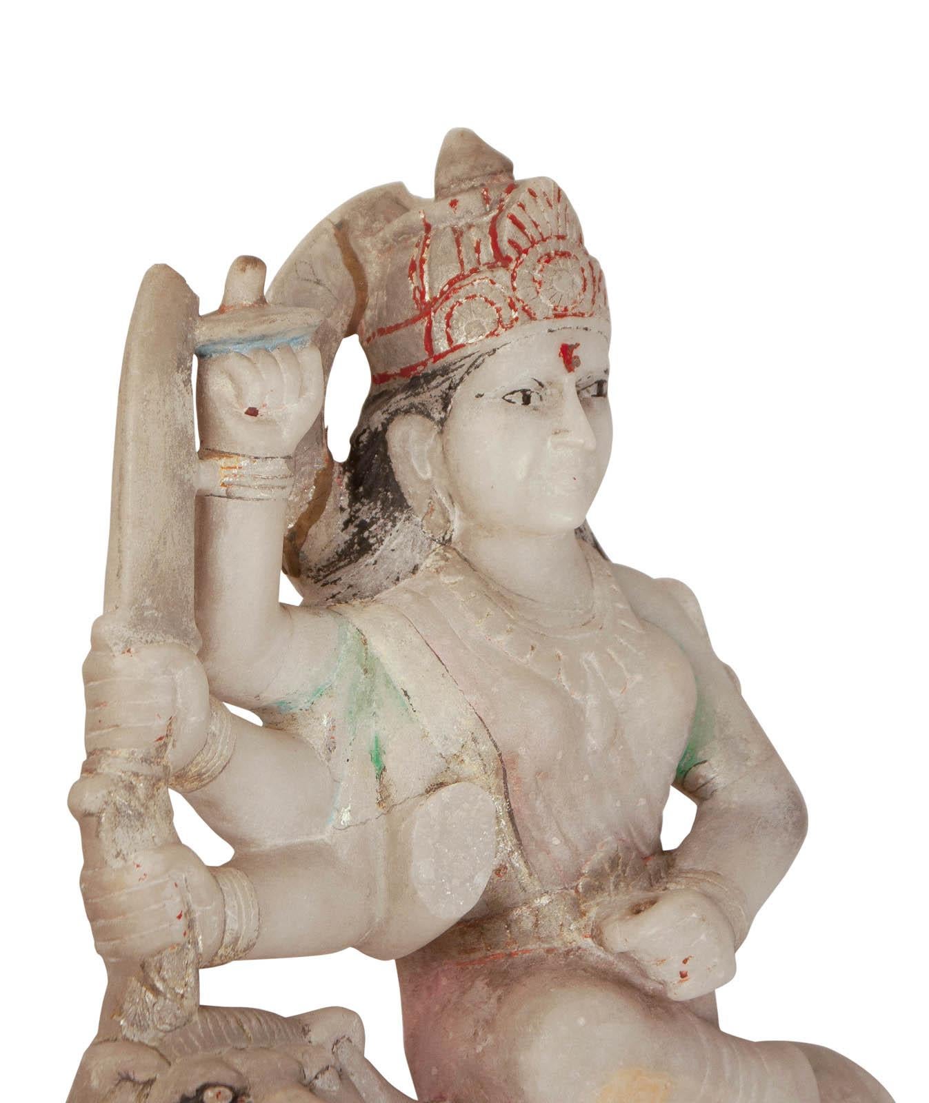A well carved Indian figure of a deity holding various attributes riding a lion. With traces of original painted decoration.