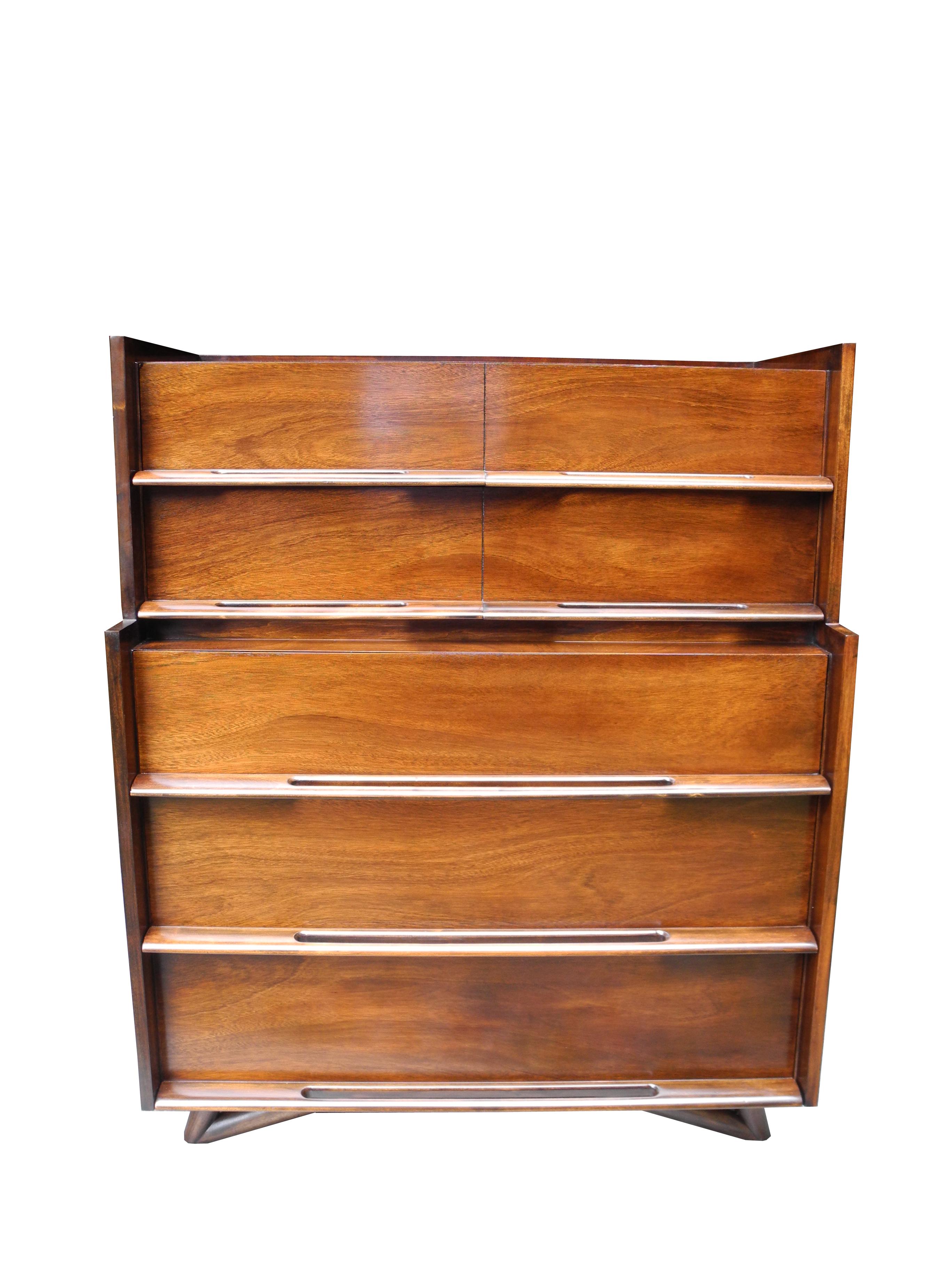 This Mid-Century Modern highboy dresser is made of cherry and is stained in dark walnut.
Equipped with five drawers there is plenty of practical storage. The handles are classic Spence design. The lip on top is perfect for containing.