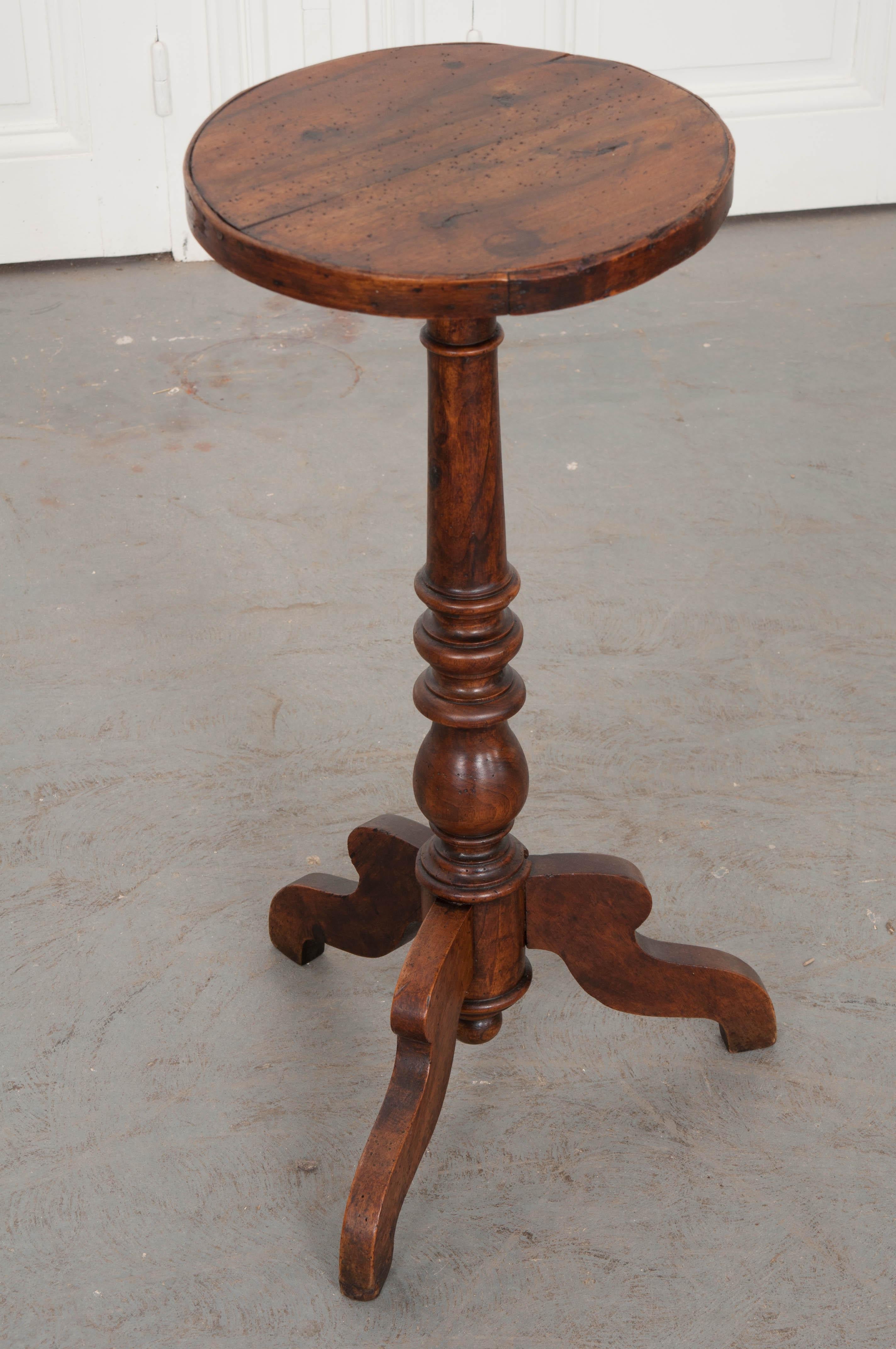 A darling round, walnut table from France. Made at the end of the 19th century, this quaint little table has loads of charm. The small circular top is finished with a wood trim band. The central support is made of turned walnut, fashioned like a