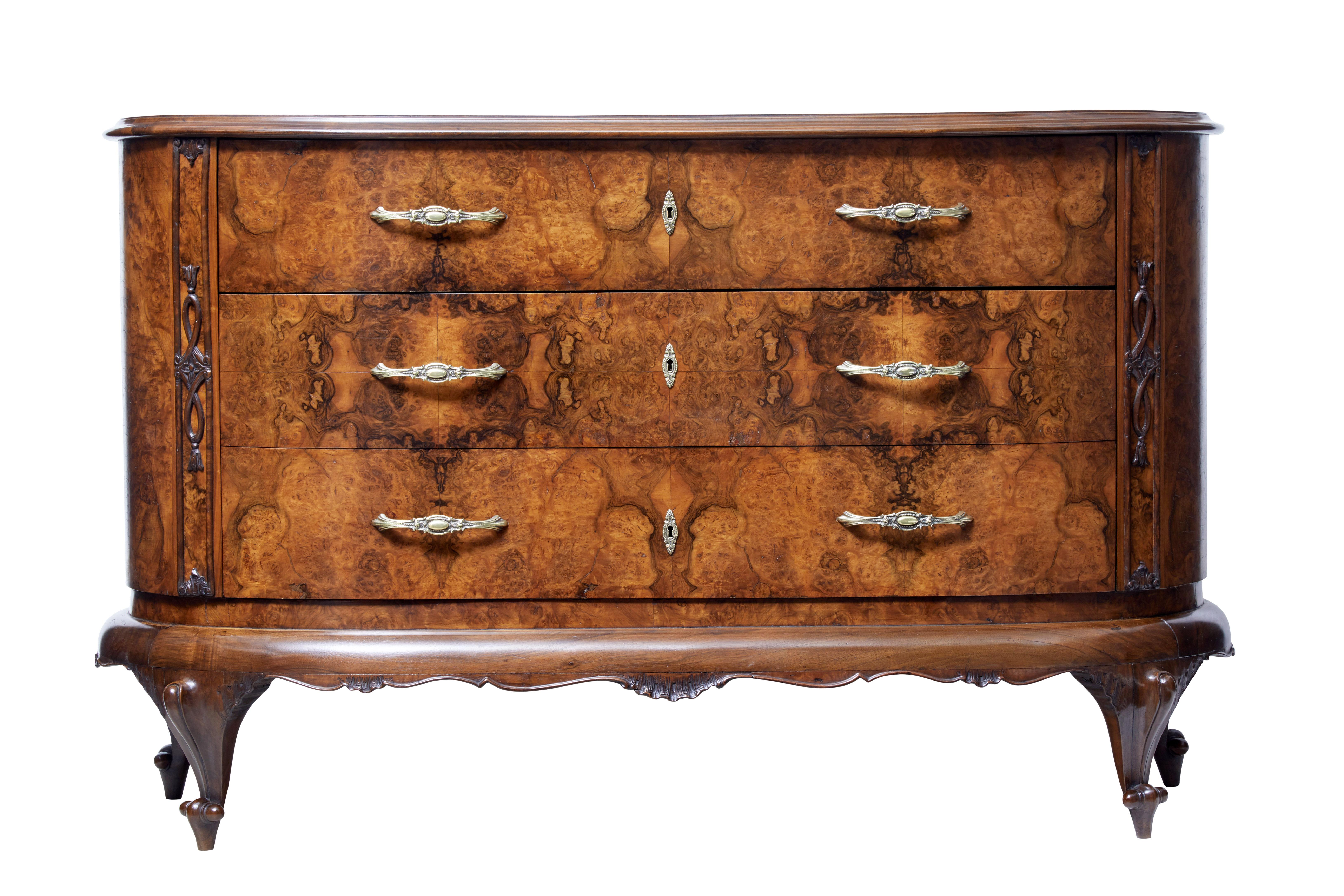Beautiful bowfront sideboard, circa 1900.

3 deep drawers with quarter veneers. Fitted with ornate brass handles and escutheons. Applied carvings to the side. Carved shells to the front freize which link to the 4 scrolling legs.

Top fitted with