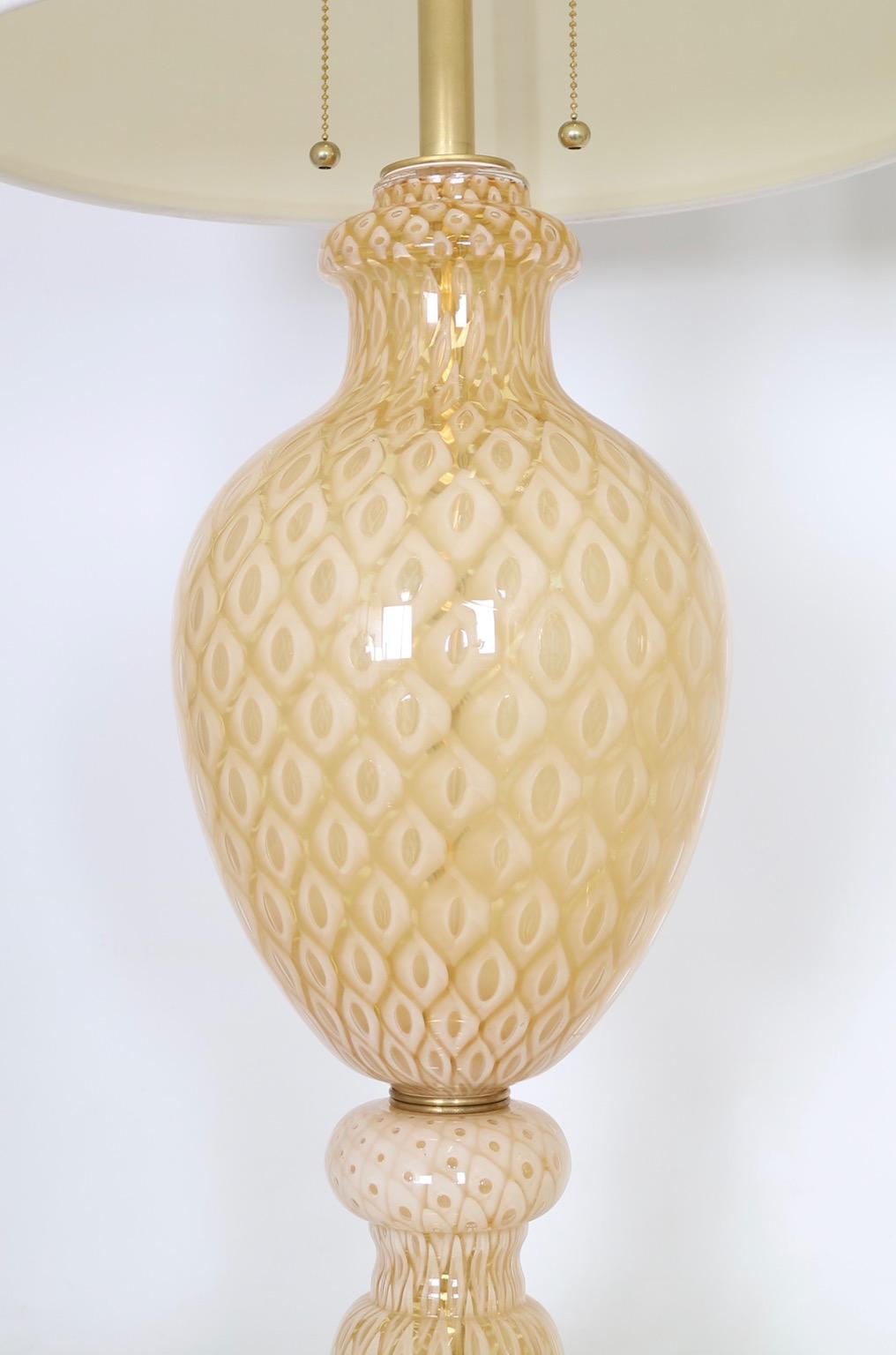 Hollywood Regency lamps by Seguso for Marbro Glass Company in gold and white Murano honeycomb glass. The lamps are bulbous in form and feature a footed glass base mounted on gilded wood. The lamps are in excellent vintage condition and are fully