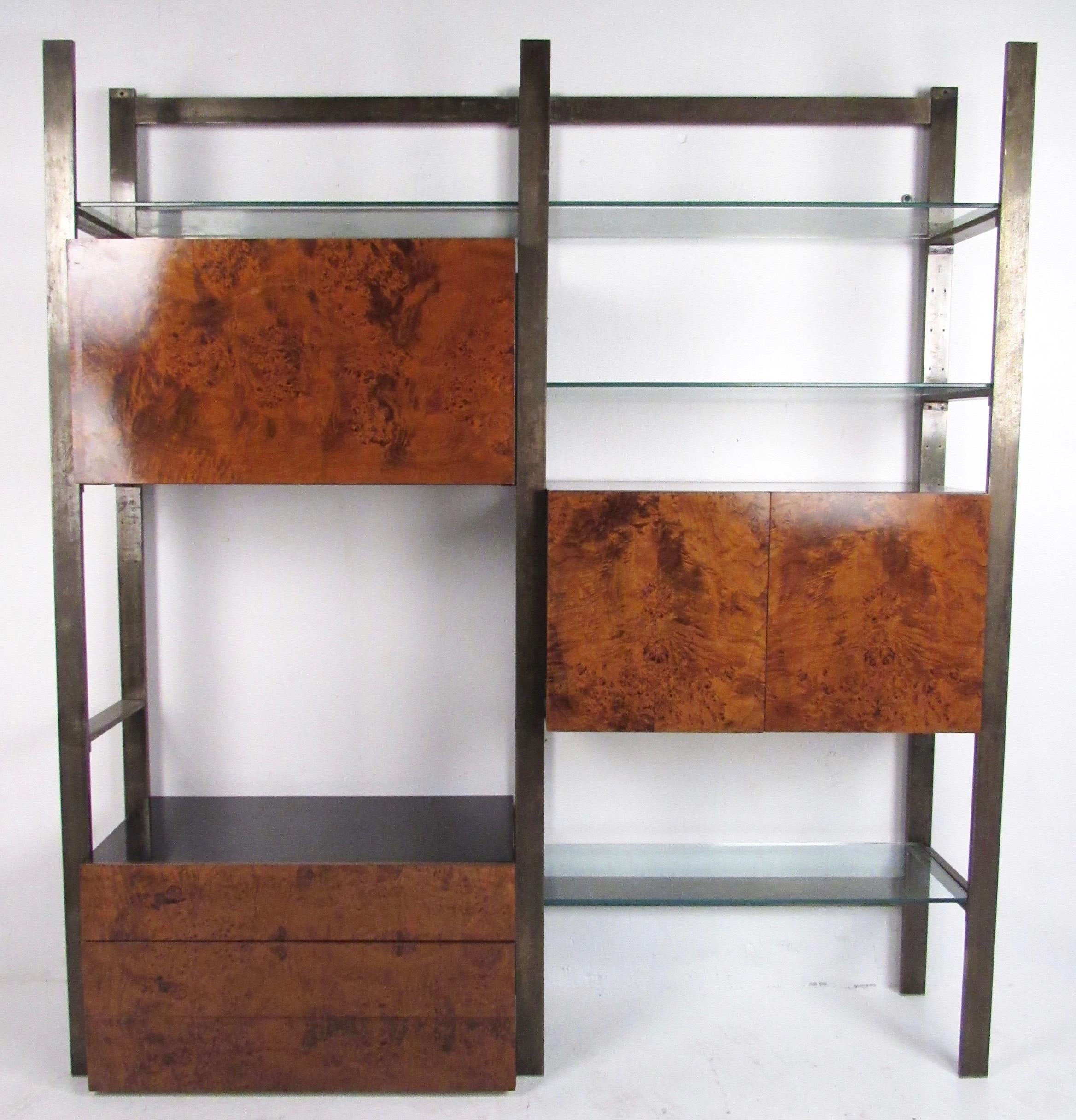 This striking Mid-Century Modern metal, glass, and burl wood wall unit makes an impressive vintage modern storage and display unit for home or showroom interior. Rich vintage burl wood cabinets along with sturdy patinated brass finish metal frame