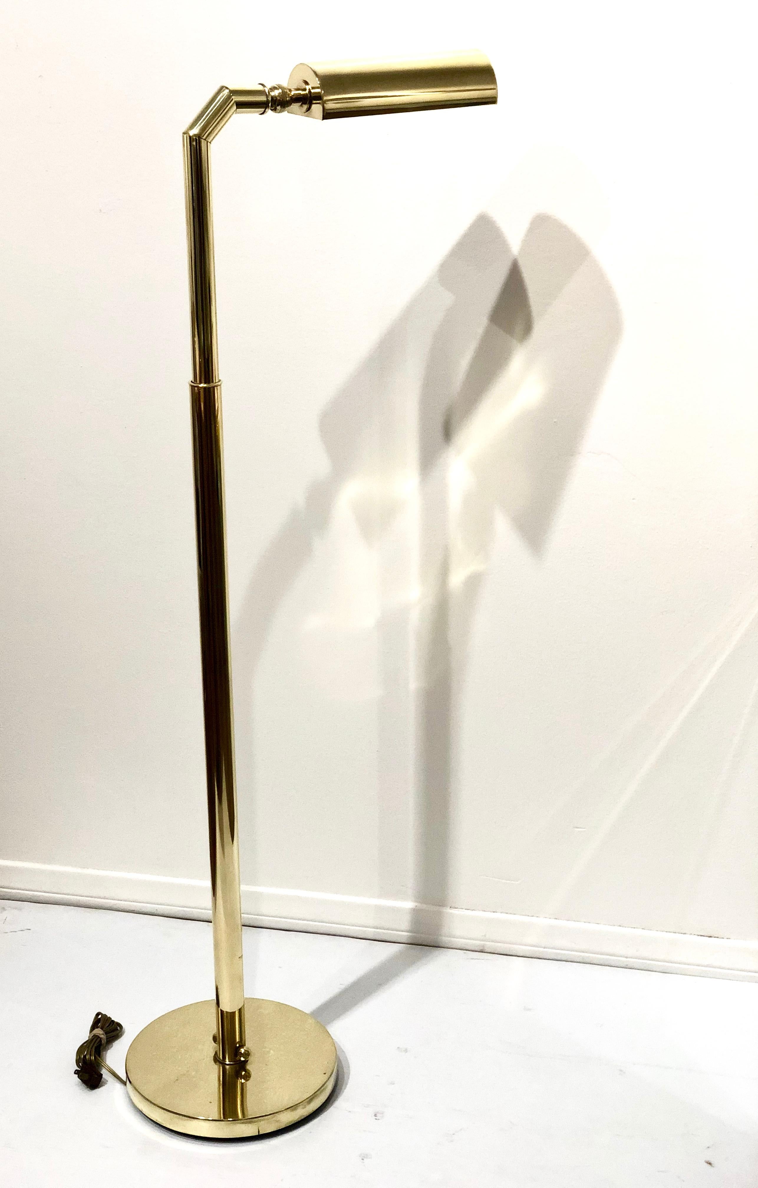 Elegant floor lamp in a polished brass finish, circa 1970s. The lamp is multi-directional (goes up and down and shade rotates from side to side) and is in good working condition. The lamp goes to 56