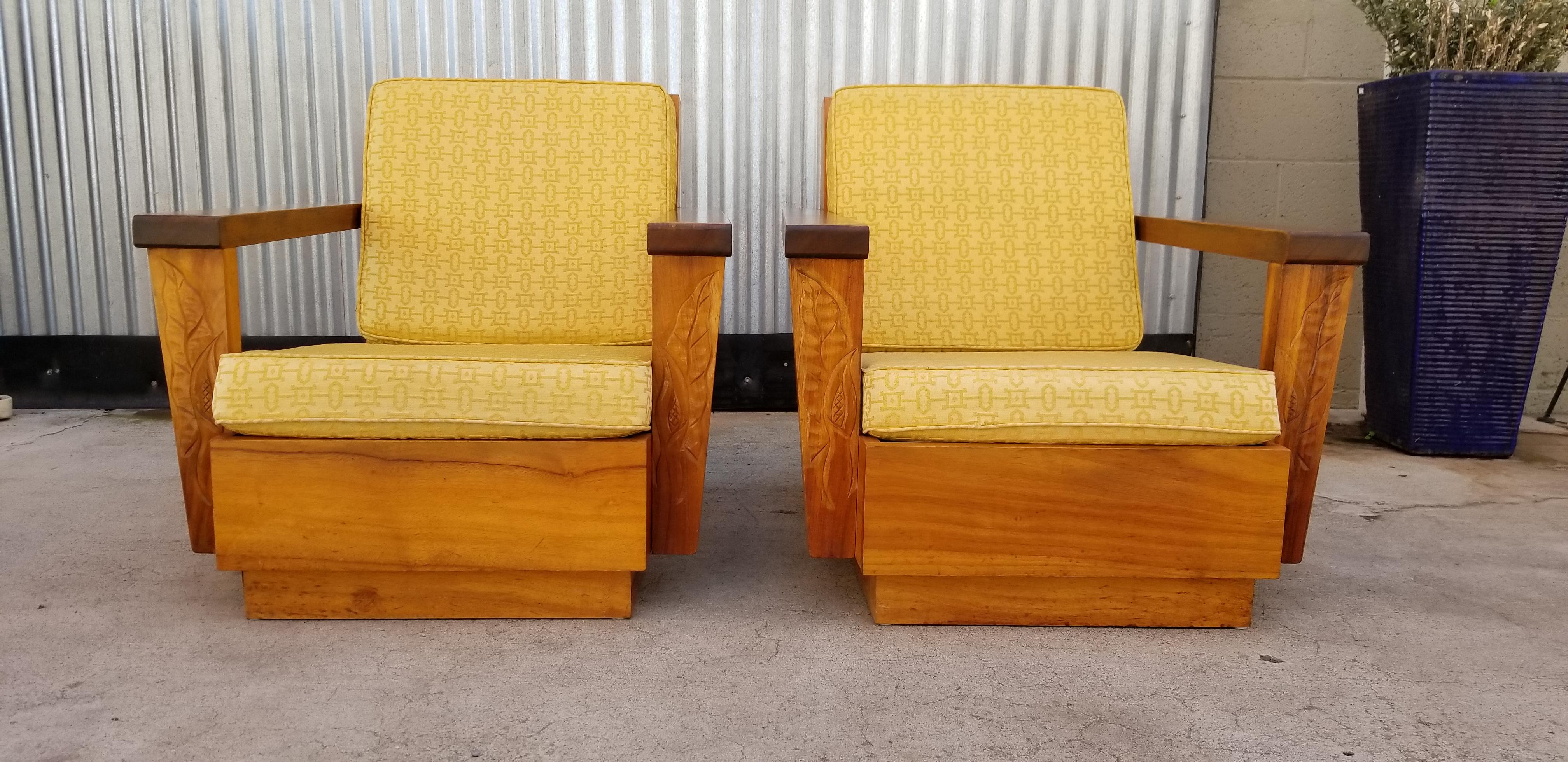 A pair of Mid-Century Modern lounge chairs made of the exotic, beautiful and scarce Koa from Hawaii, circa 1960s. Original finish with warm patina and depth to finish. Hand carved detail of anthuriam. Cushions in need of new upholstery, therefore,