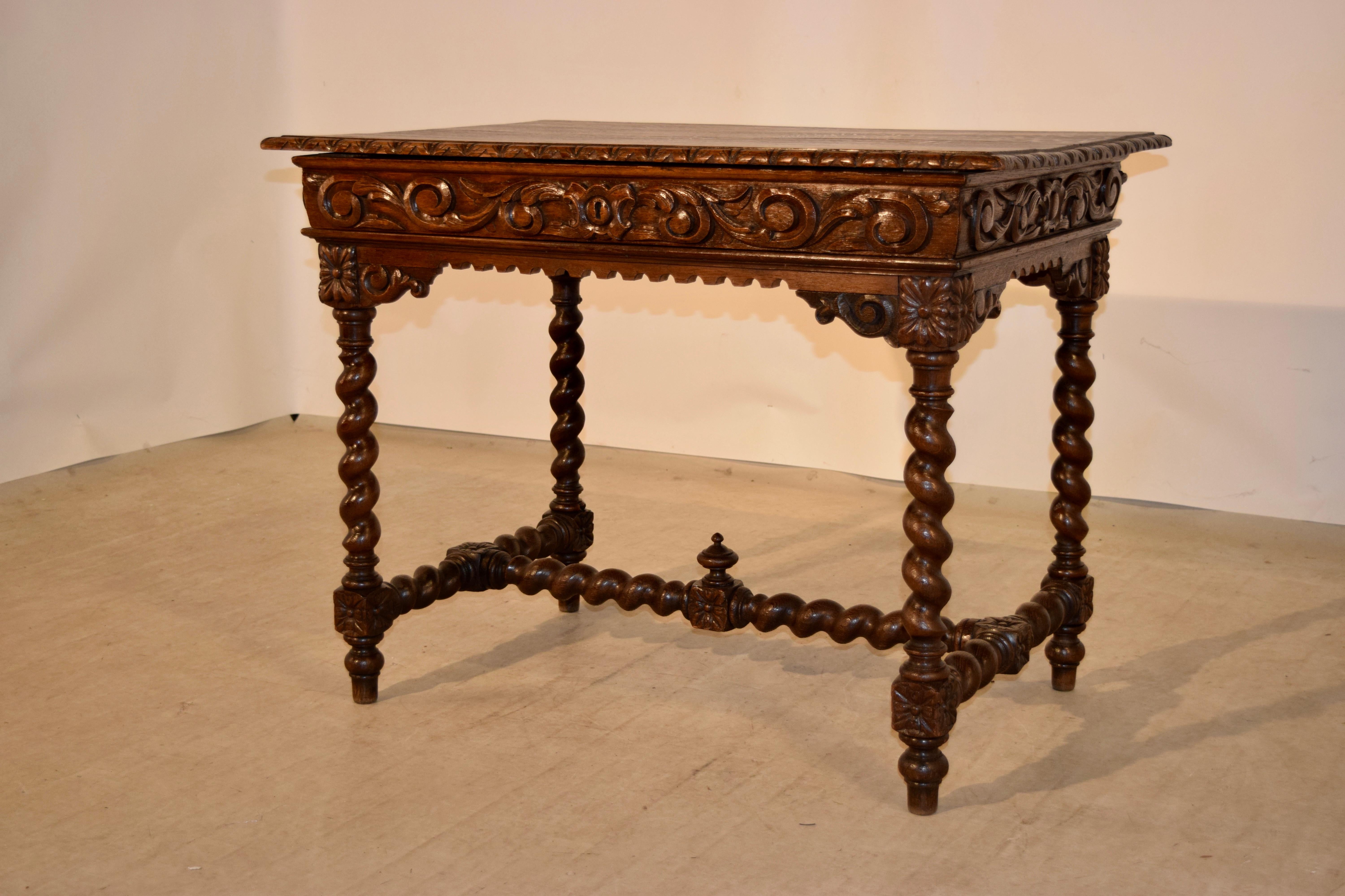 19th century library table from France made of oak. The top has a bevelled and carved decorated edge around the top following down to a hand carved decorated apron on all four sides, for easy placement in any room. The front of the table contains a