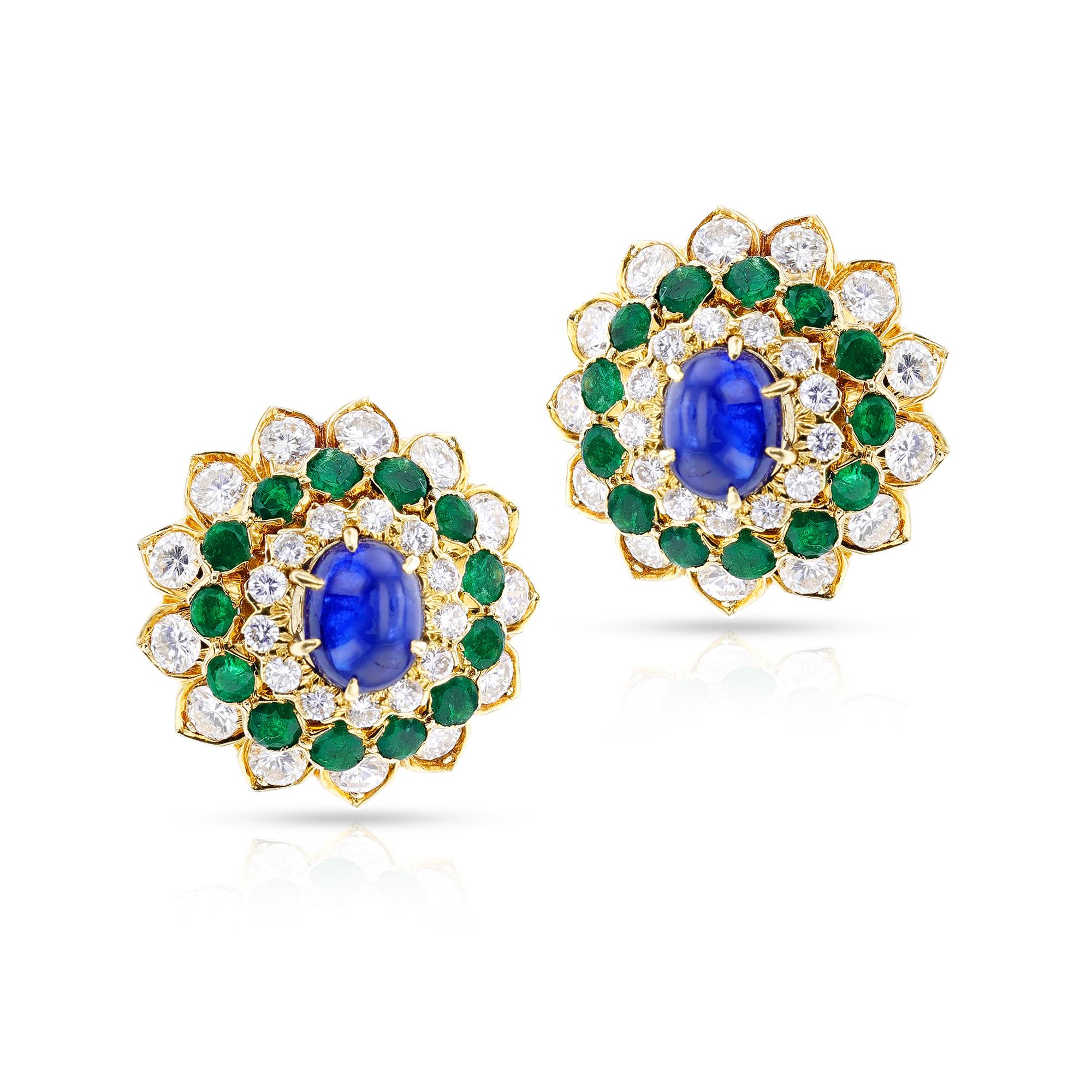 A pair of stunning David Webb Sapphire Cabochon, Emerald and Diamond Earrings made in 18k Yellow Gold. These floral earrings with a sapphire cabochon, and round emeralds and diamonds This luxurious combination of precious gemstones and metals will
