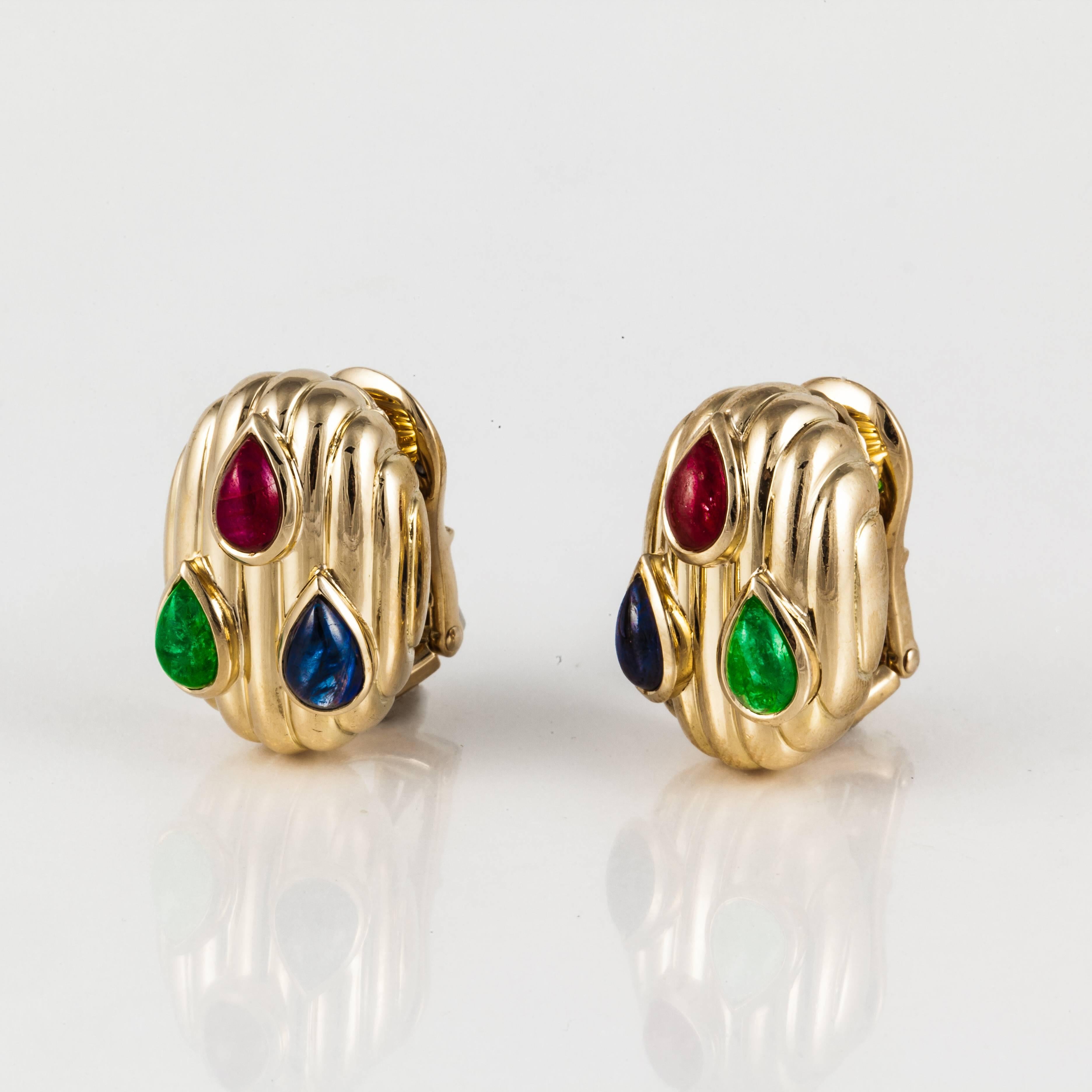David Webb earrings in 18K yellow gold featuring cabochon emeralds, rubies and sapphires.  They measure 13/16 inches long and 9/16 inches wide.  Clip style.