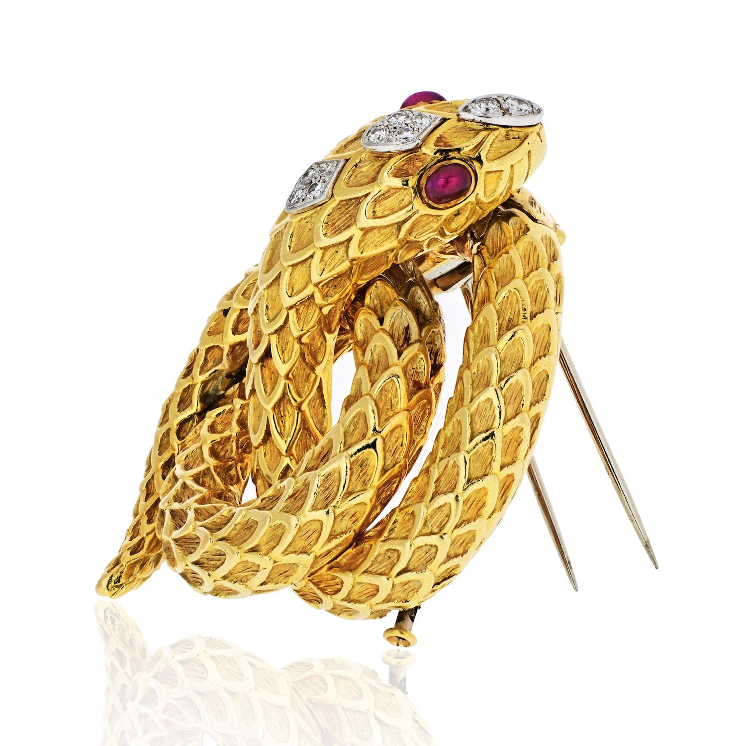 This very rare yellow gold and platinum Serpent brooch by David Webb is accented by cabochon oval cut ruby eyes and 10 round cut diamonds on it's head. This serpent wraps his body around his head twice and looks very compact. 
Intricate finishes to