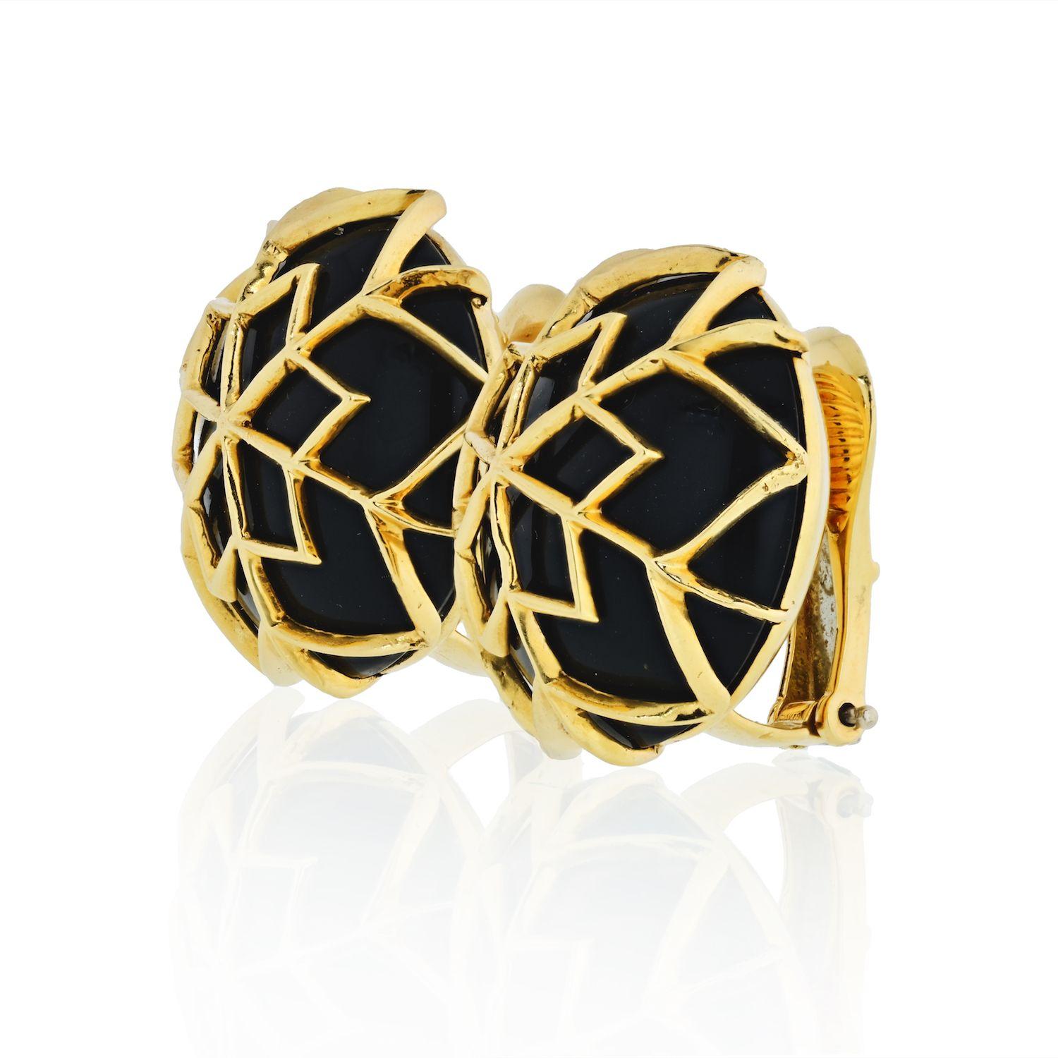These exquisite estate David Webb clip-on earrings boast a captivating design featuring round onyx cabochons with delicate overlays, all meticulously mounted in lustrous 18k yellow gold. The signature 