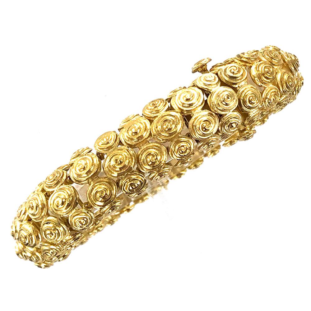David Webb swirl estate bracelet fashioned in 18 karat yellow gold. The textured bracelet measures 7.75 inches in length and .60 inches in width. Signed Webb 18K. 