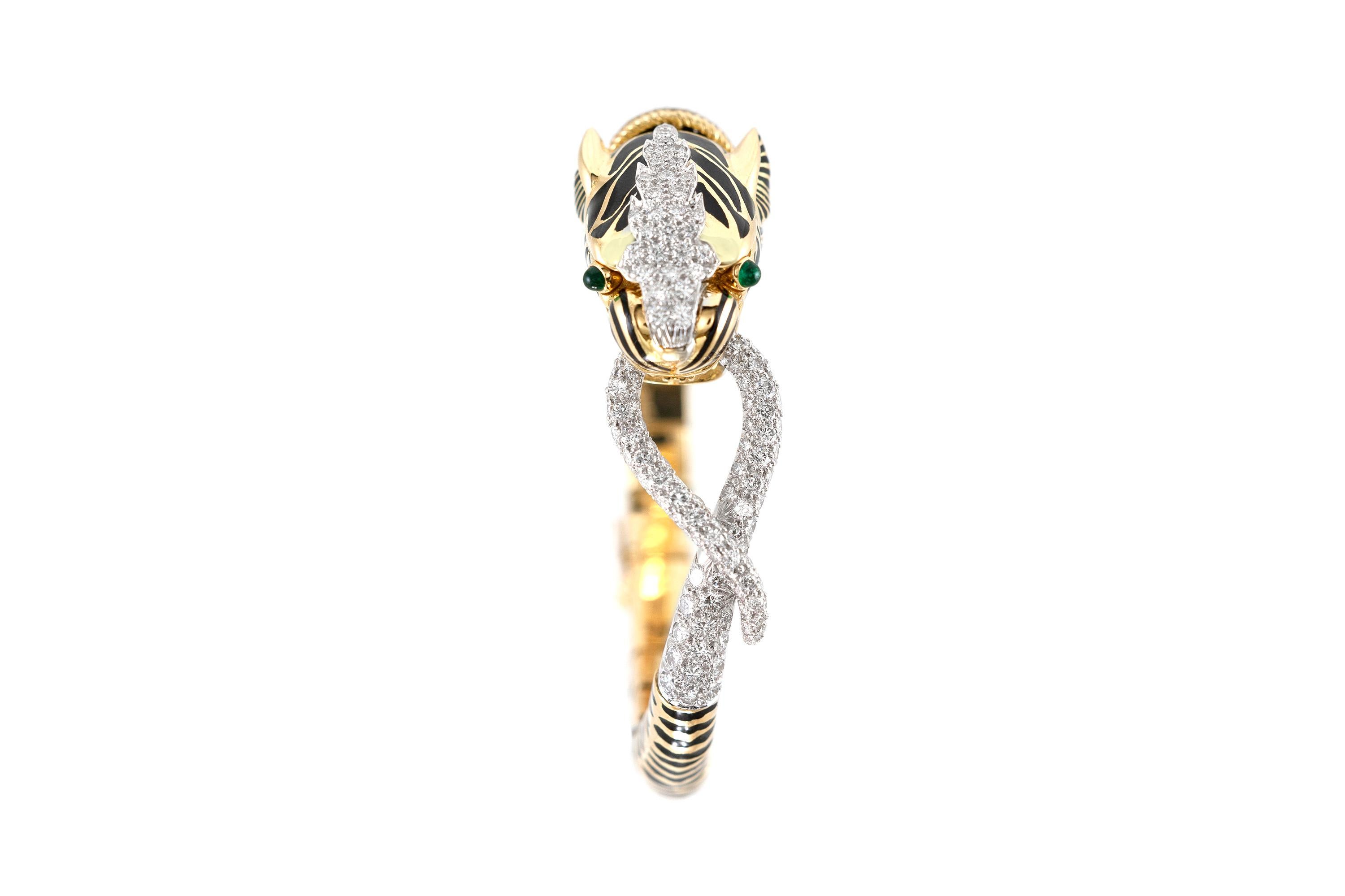 Finely crafted in 18k yellow gold and black enamel with round brilliant cut Diamonds weighing approximately a total of 5.45 carats.
F-G color, VVS-VS clarity
The bracelet features two Cabochon Emeralds, as the eyes of the tiger, weighing