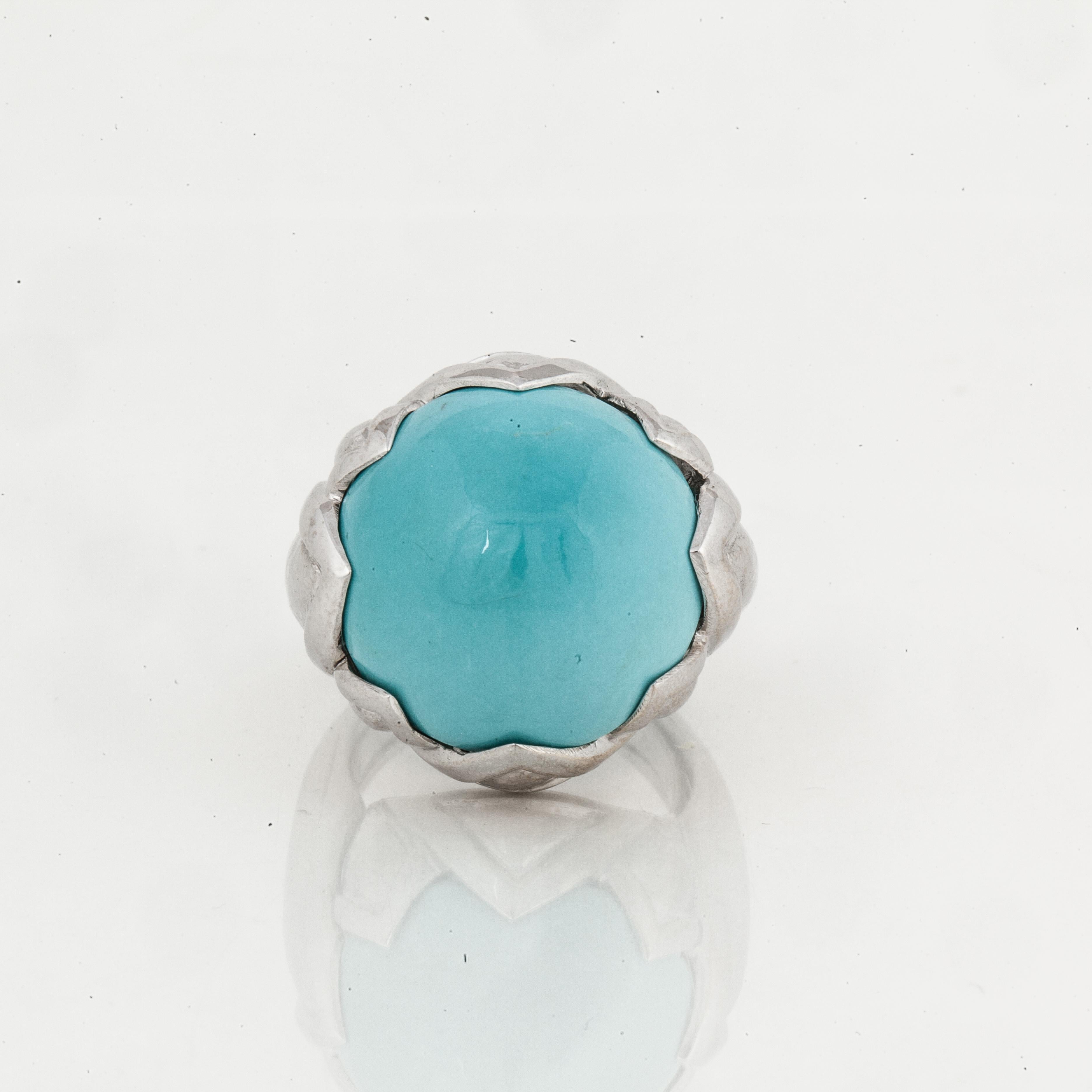 David Webb 18K white gold ring.  Features a round cabochon turquoise stone in the center.  The metal is hammered with the gold work coming up and around the turquoise. Ring is currently a Size 5 with a butterfly.  Measures 7/8