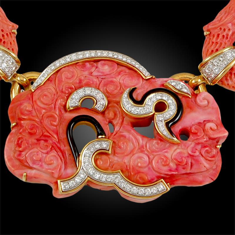 Comprising an exceptional necklace from the David Webb Ancient World collection, finely crafted with two-tone carved vibrant coral, accented with luminous diamonds and black enamel, linked together by 18k yellow gold. 
Signed David Webb.